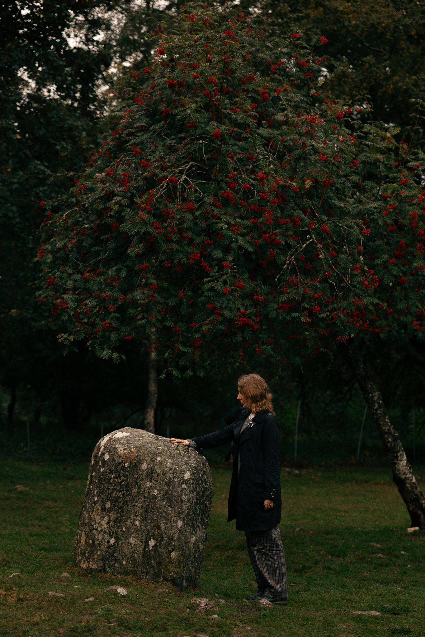 Girl touching stone in Clava Cairns Scotland.
