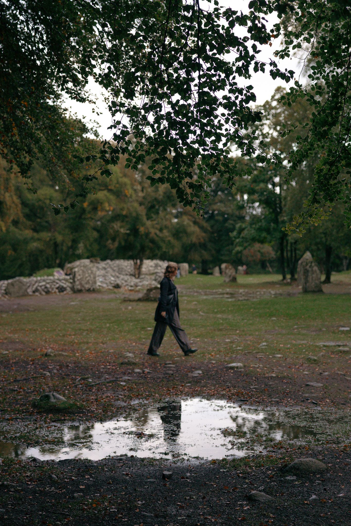 Reflection of a girl walking in Clava Cairns, Scotland.