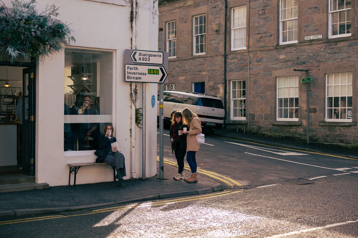 Girls enjoying coffee outside a cafe in Dunkeld, Scotland.