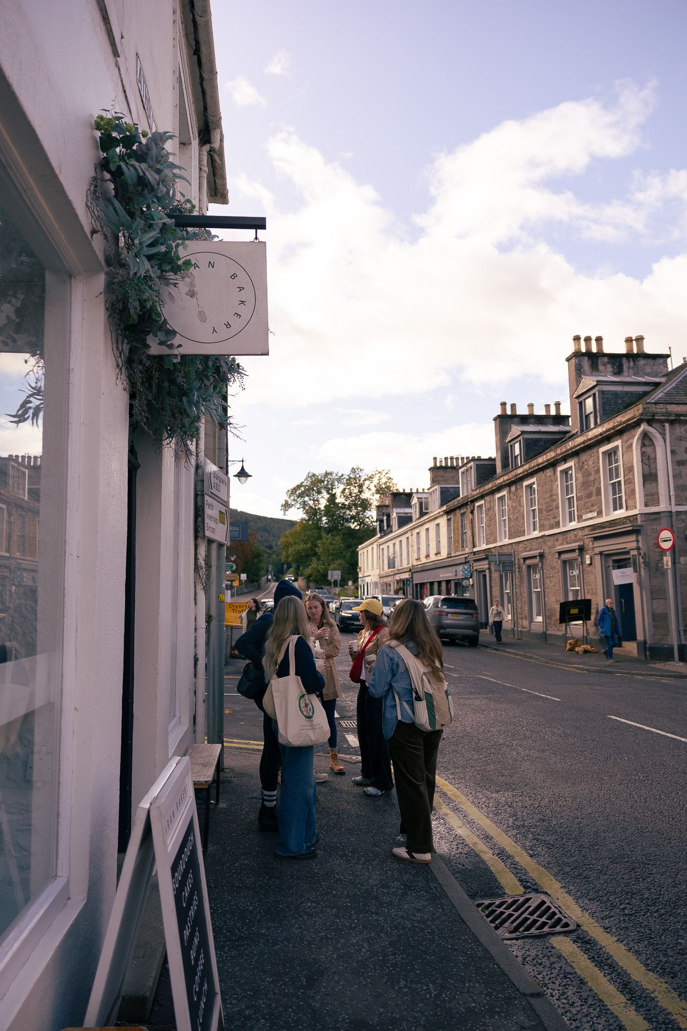 Girls enjoying coffee outside a cafe in Dunkeld, Scotland.