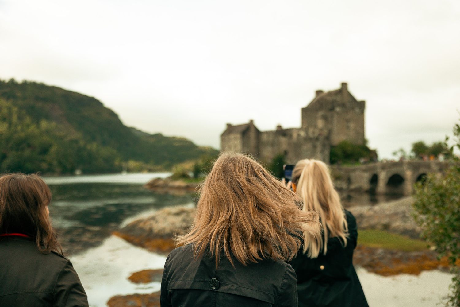Girls standing in front of Eilean Donan Castle.