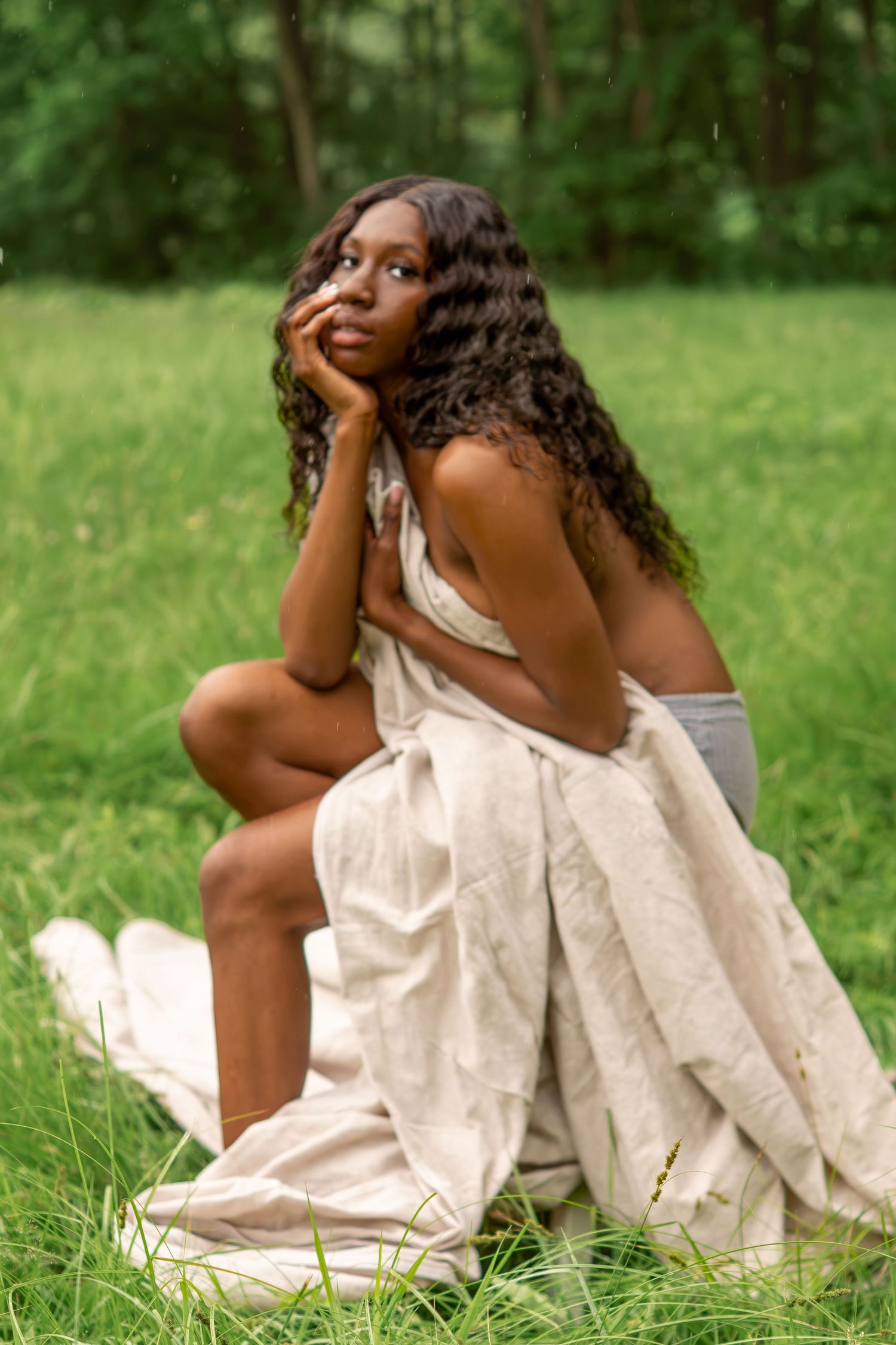Woman seated outdoors in a white dress for a romantic bridal portrait