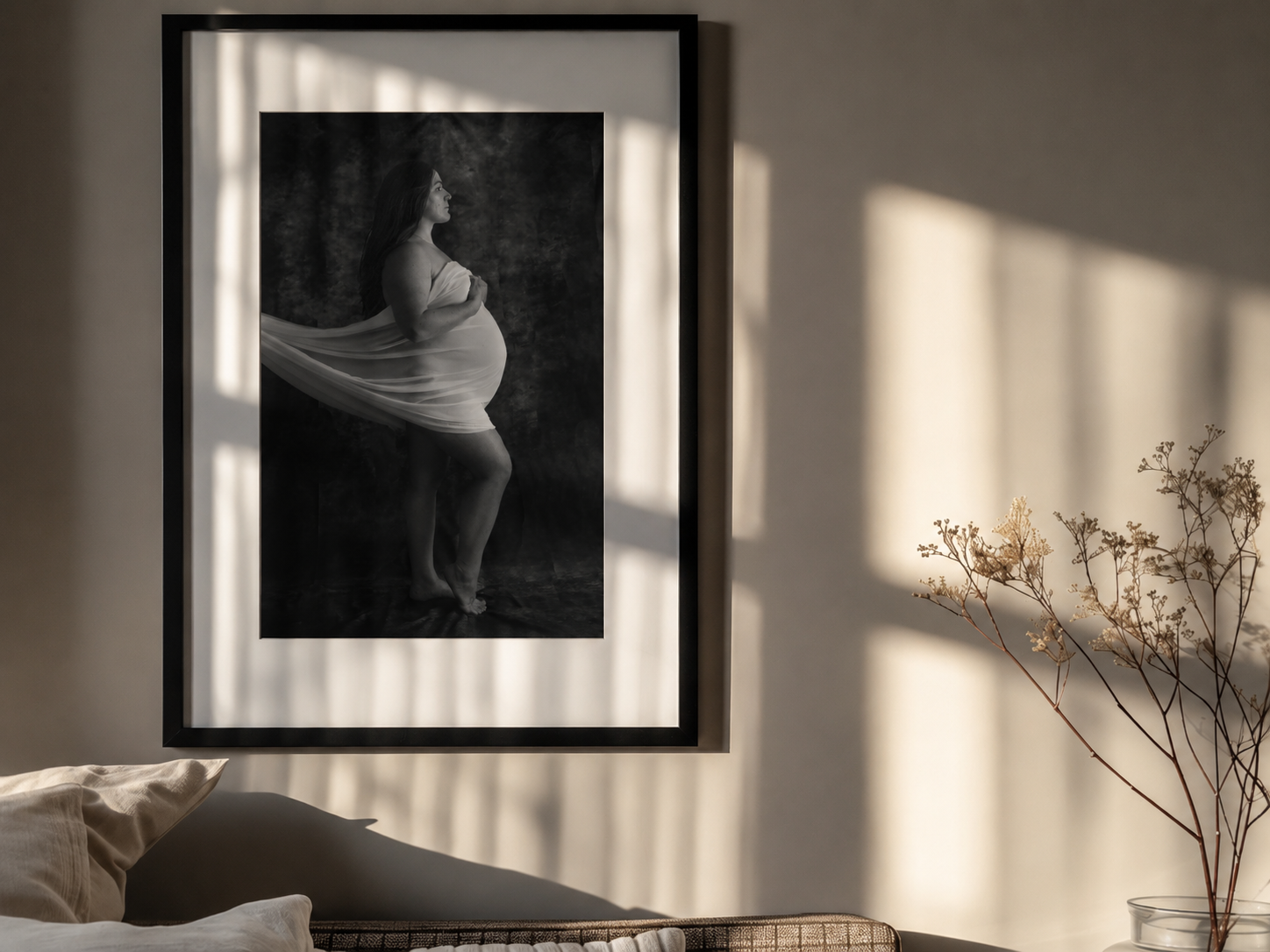 framed fine art maternity portrait hanging on the wall next to a chair