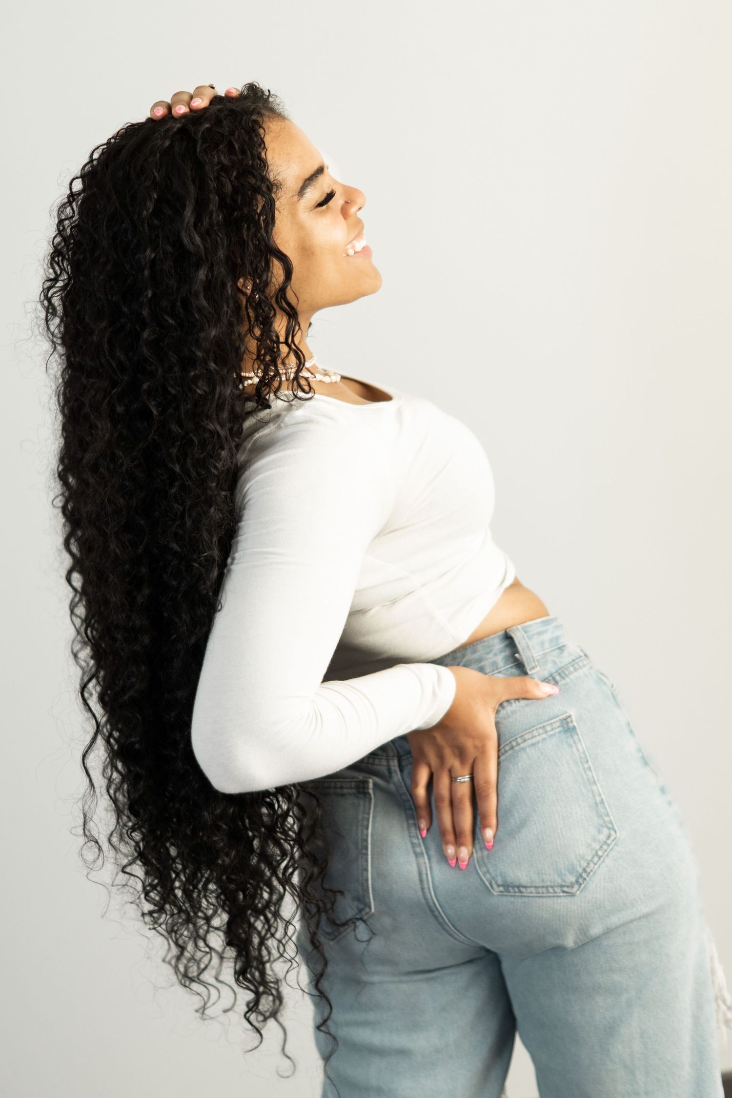women showing off her long hair in an editiorial photography image taken in elmira portrait studio wearing blue jeans and simple shirt