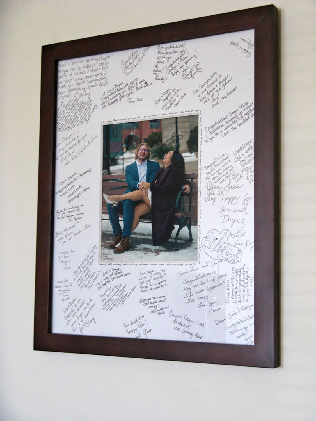 Framed wedding portrait display featuring an engagement photograph for guests to sign