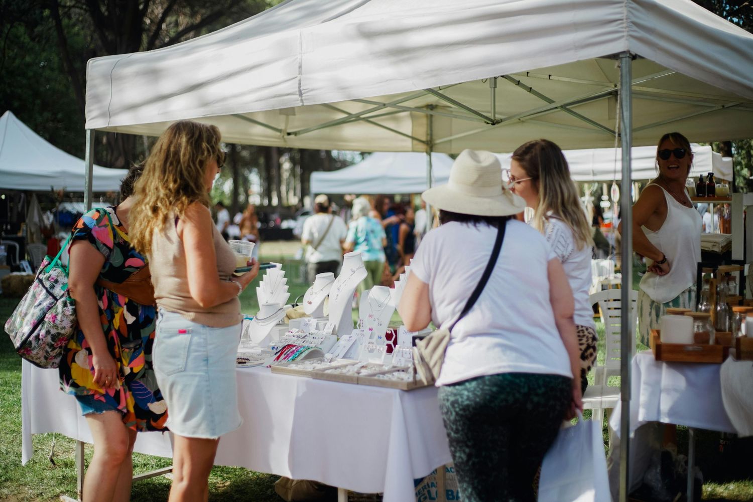 vendor table selling jewelry to women at a market