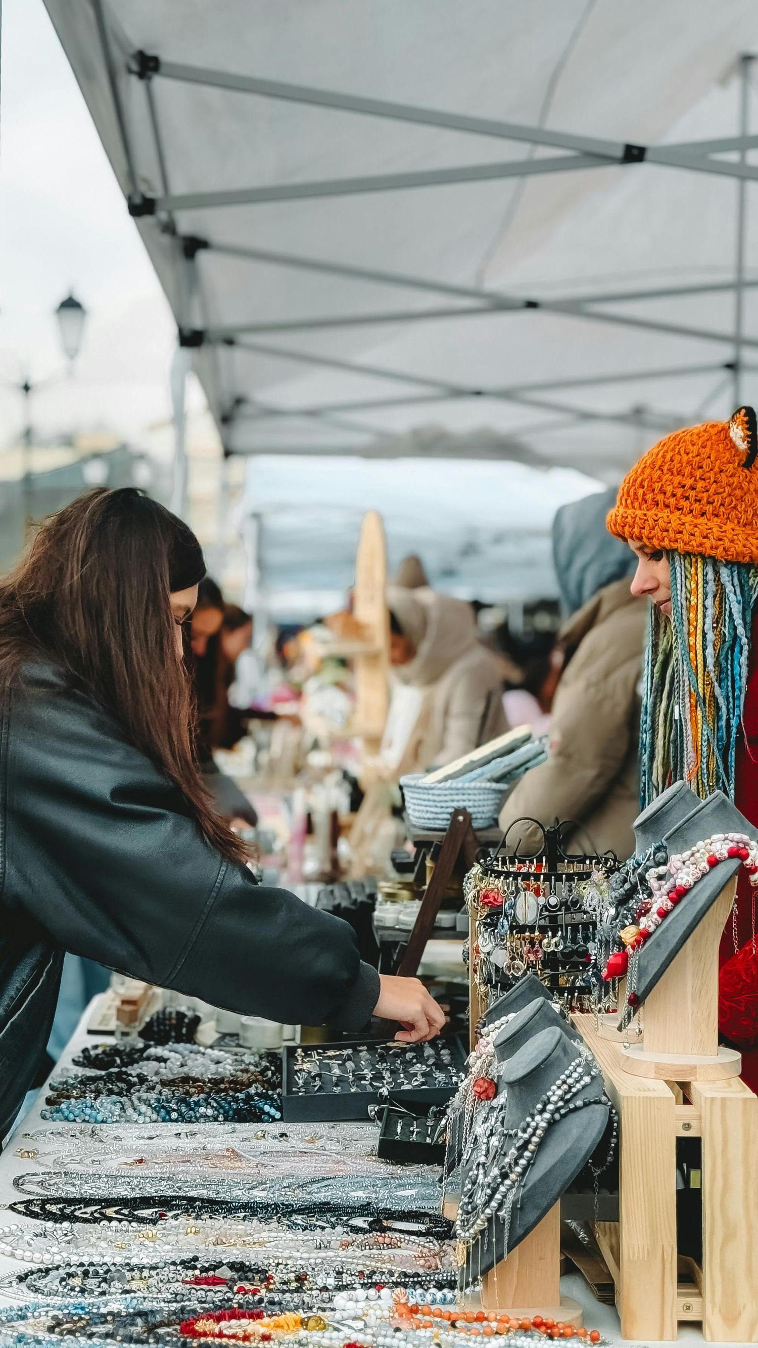 women wearing an orange hat talking about the market table