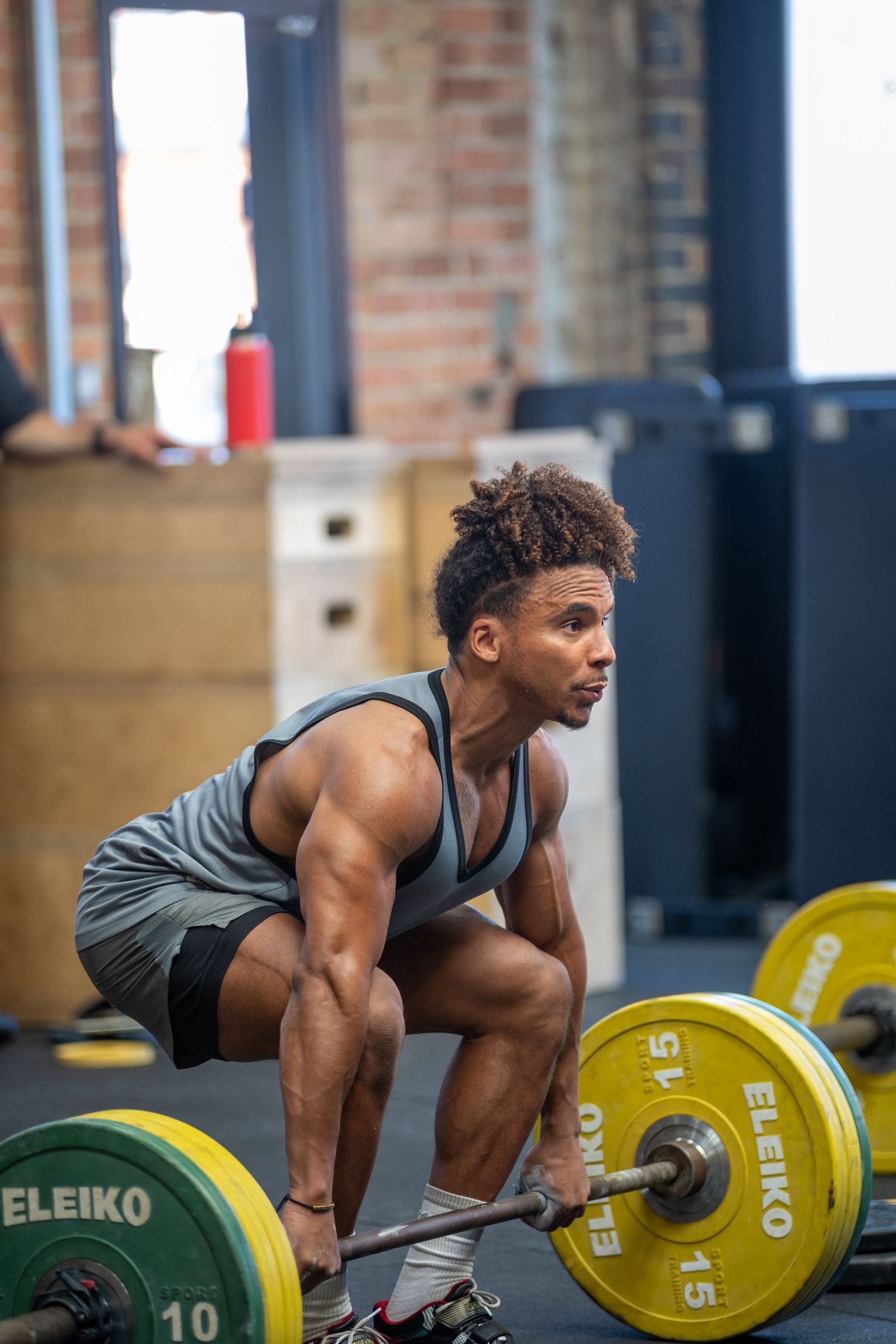 Athletic man performing a deadlift with an Eleiko barbell in a crossfit gym.