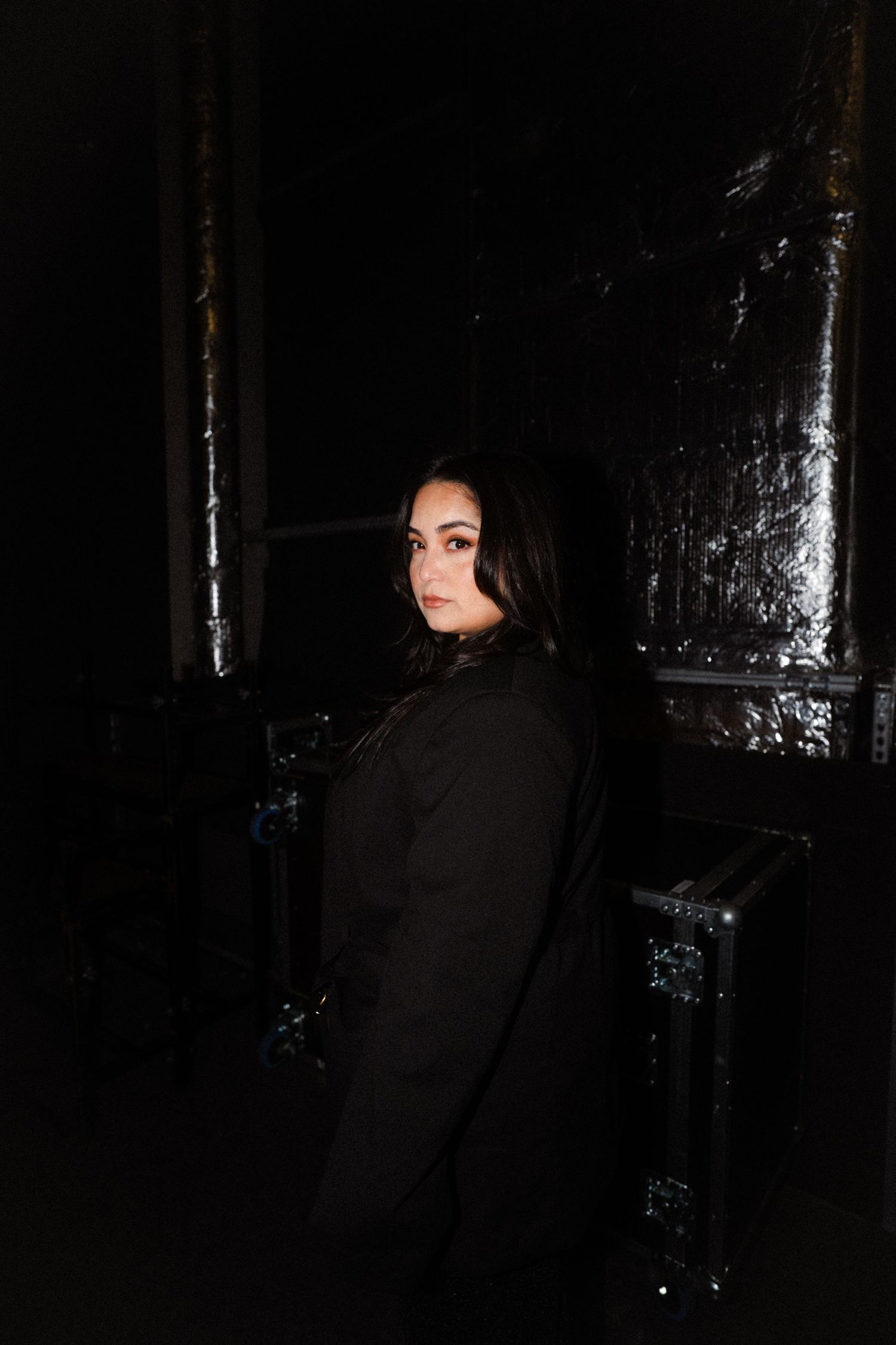 Bahar Kizil against reflective surface in low-light setting.