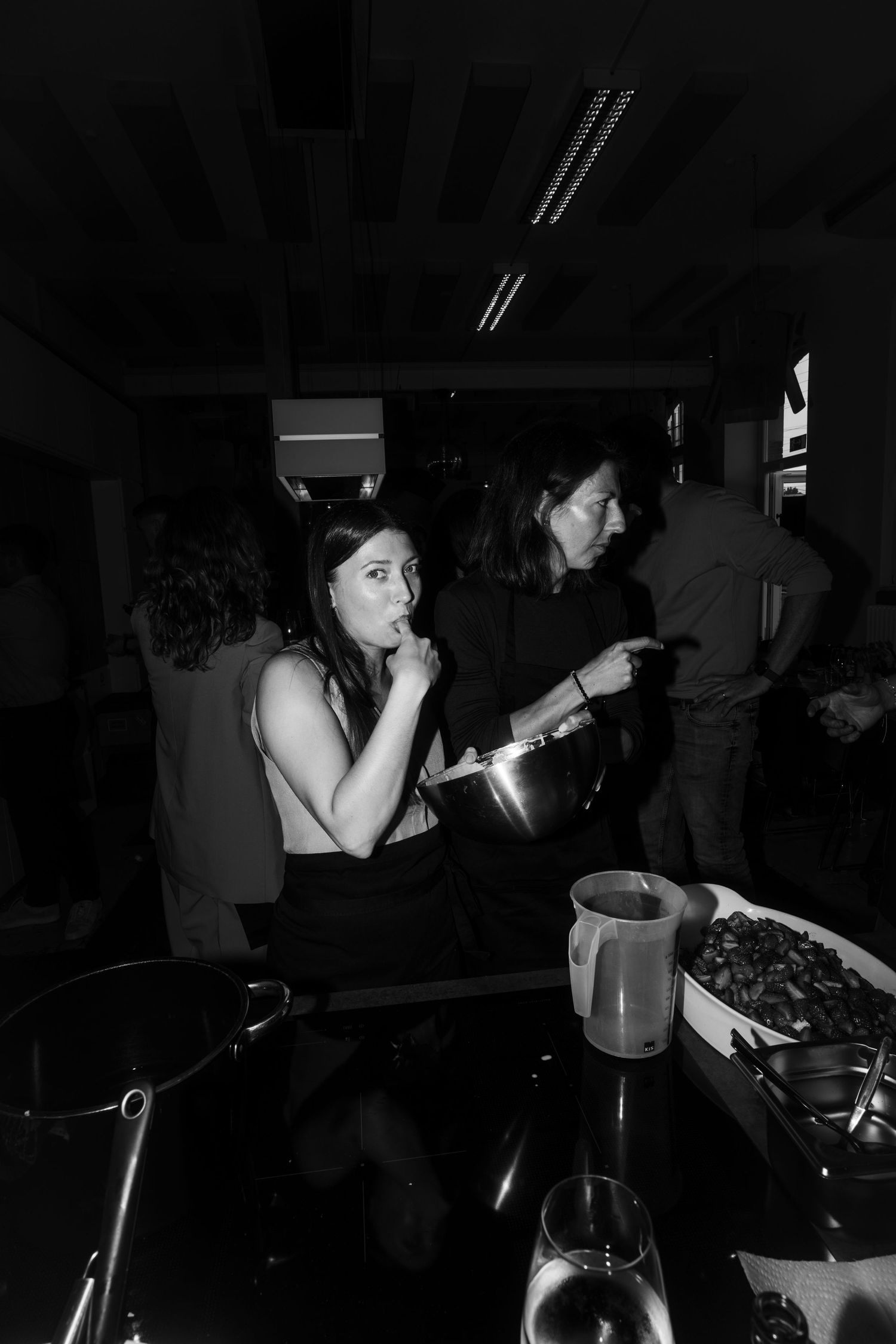 People enjoying drinks and socializing in a dark indoor space.