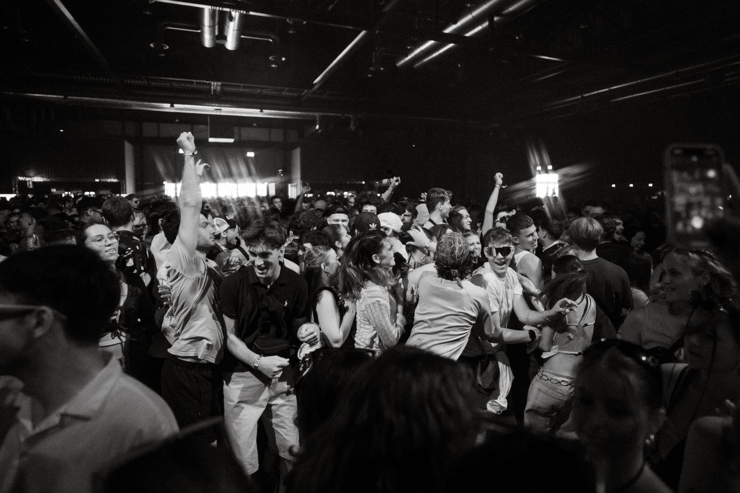 Energetic crowd dancing and jumping at an indoor music venue.