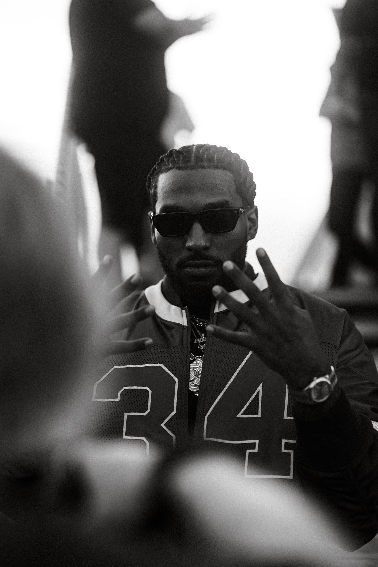 Artistic black and white sequence of Reezy in silhouette wearing sunglasses during a stage show.