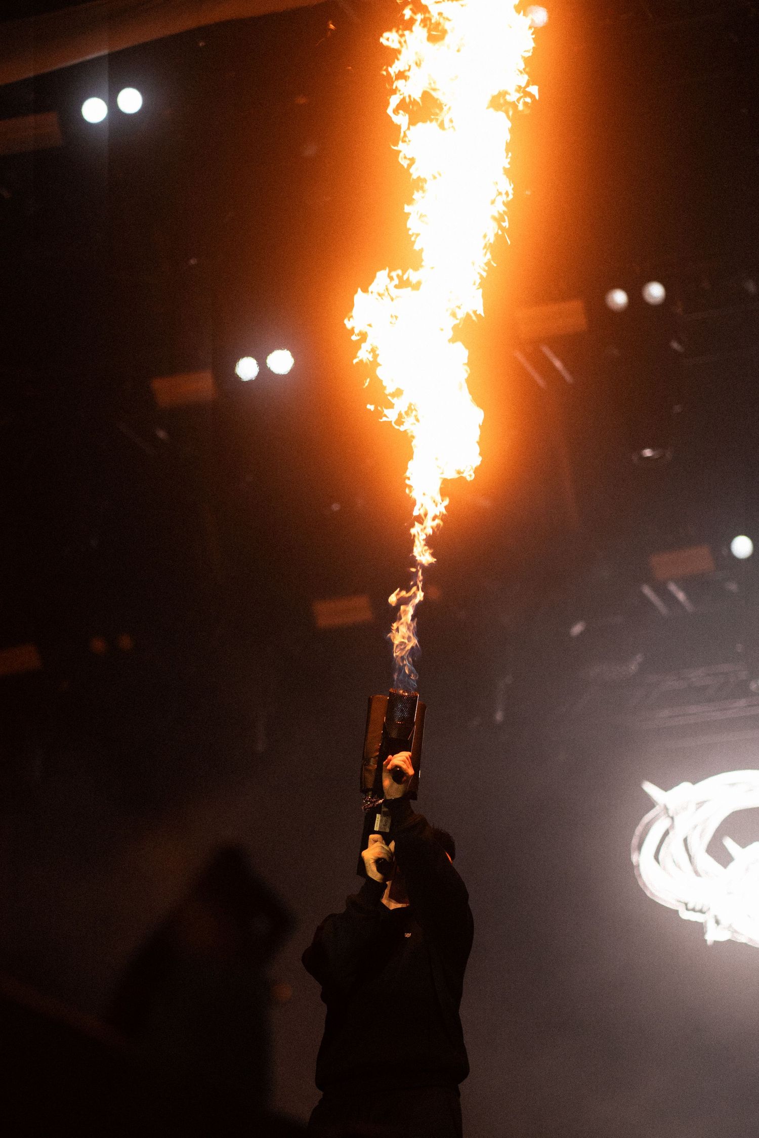Dramatic pyrotechnic display shooting flames upward during dark stage performance.