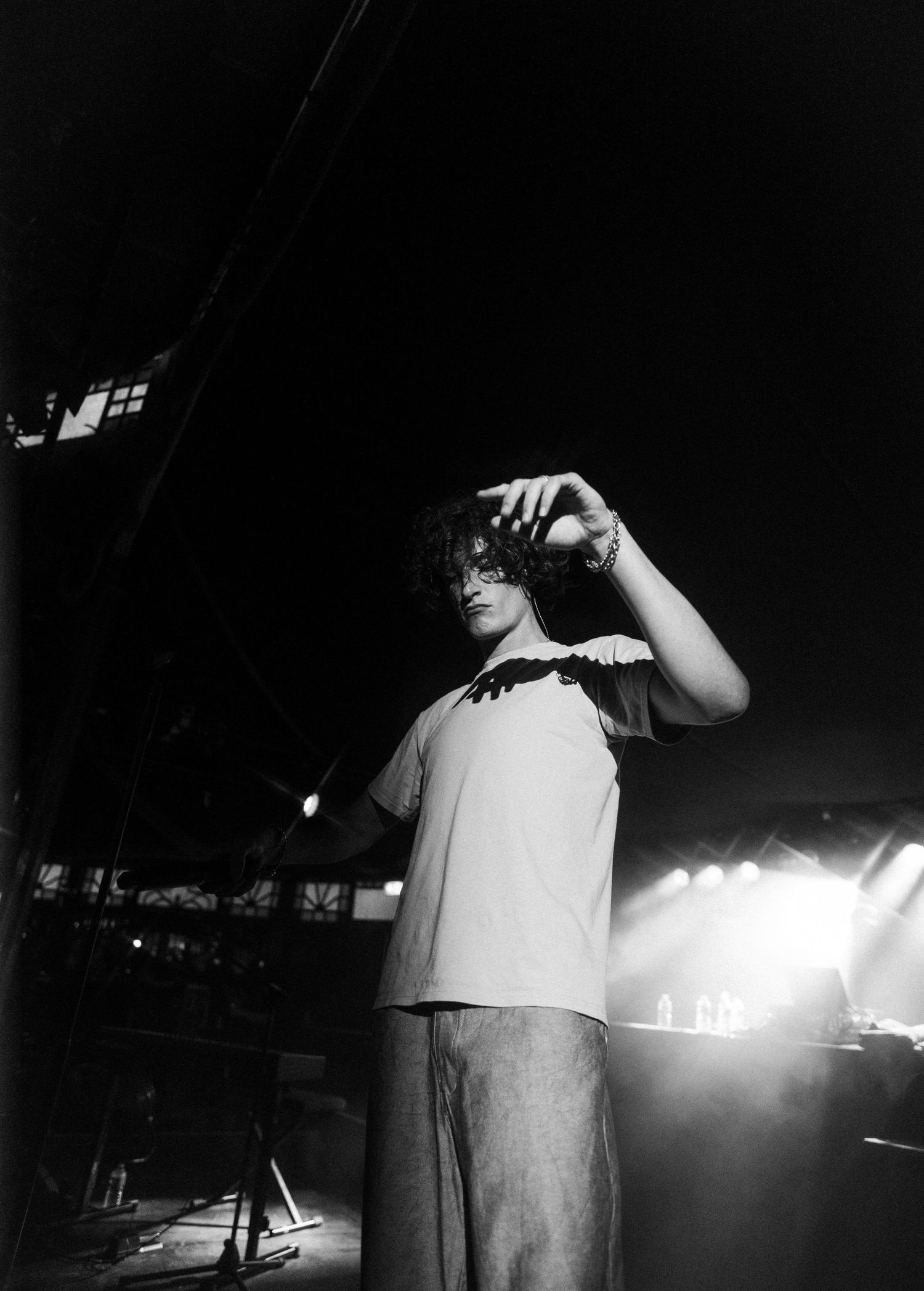 Concert performer on stage in dramatic black and white lighting.