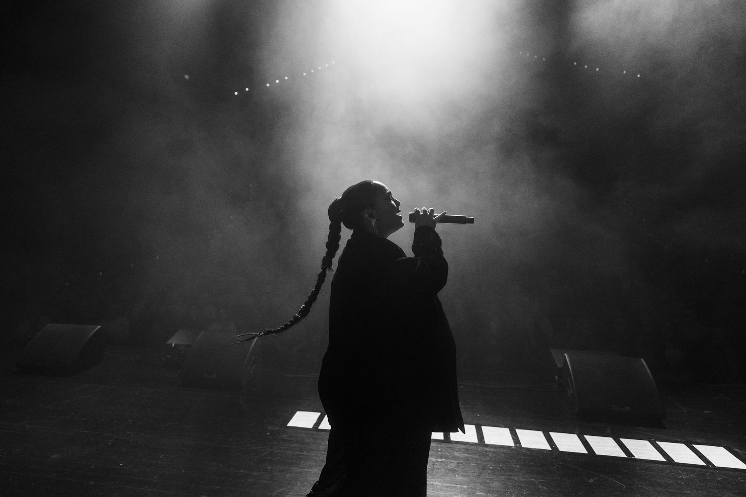 Dramatic silhouette of Bahar Kizil in fog with bright spotlights on stage.