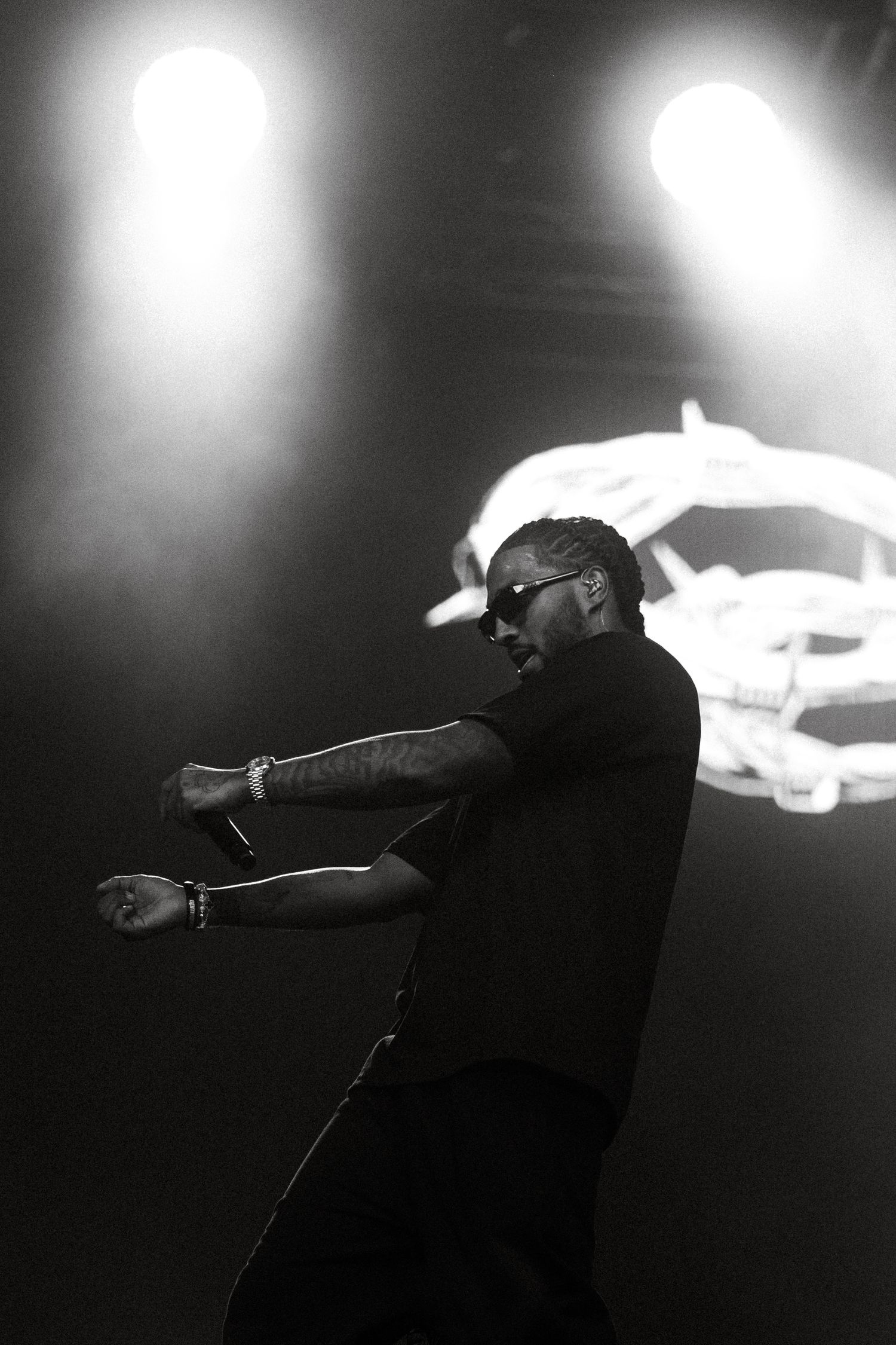 Dramatic silhouette of Reezy making dynamic movements against bright stage lighting.