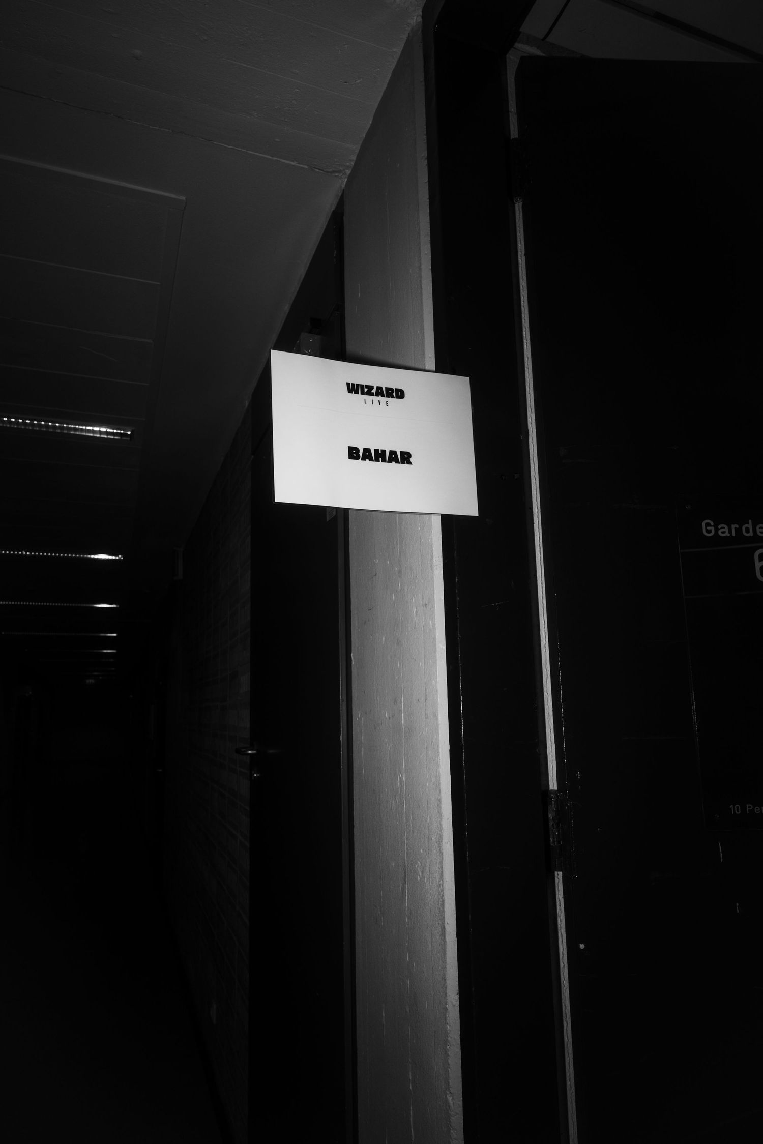 Dark corridor interior with illuminated signs mounted on walls creating stark contrast.
