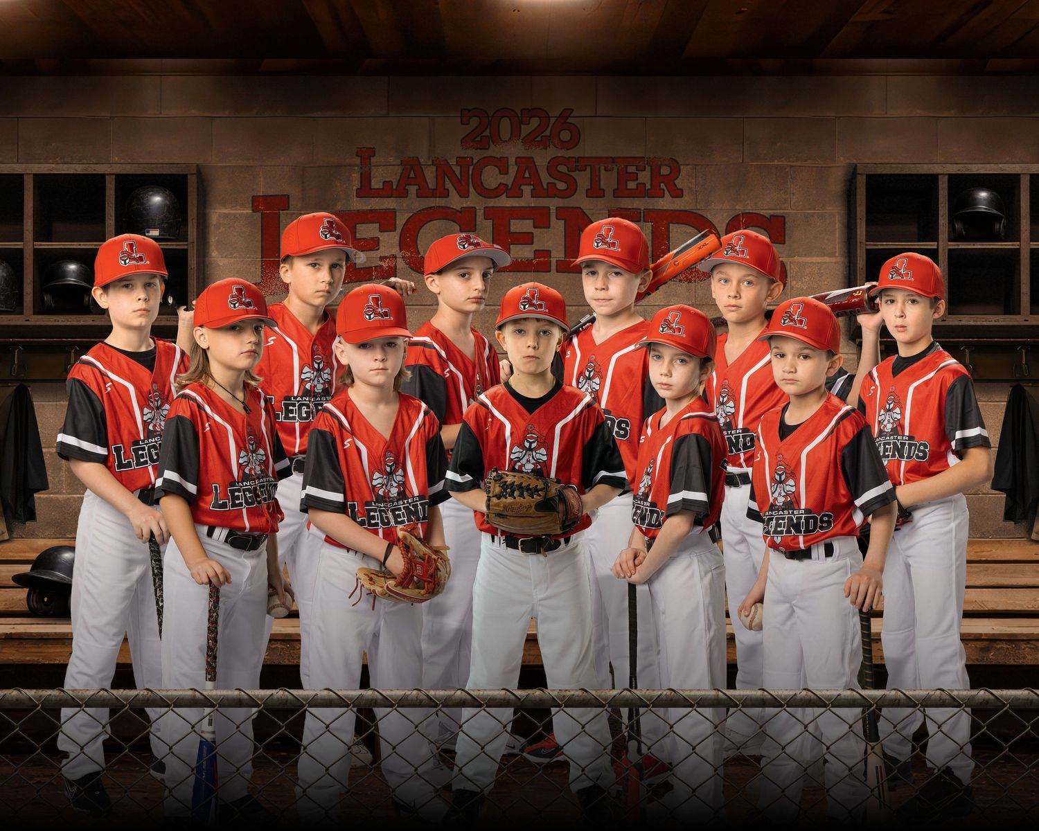 Baseball team in red uniforms poses together for a panoramic team photo on wooden benches.