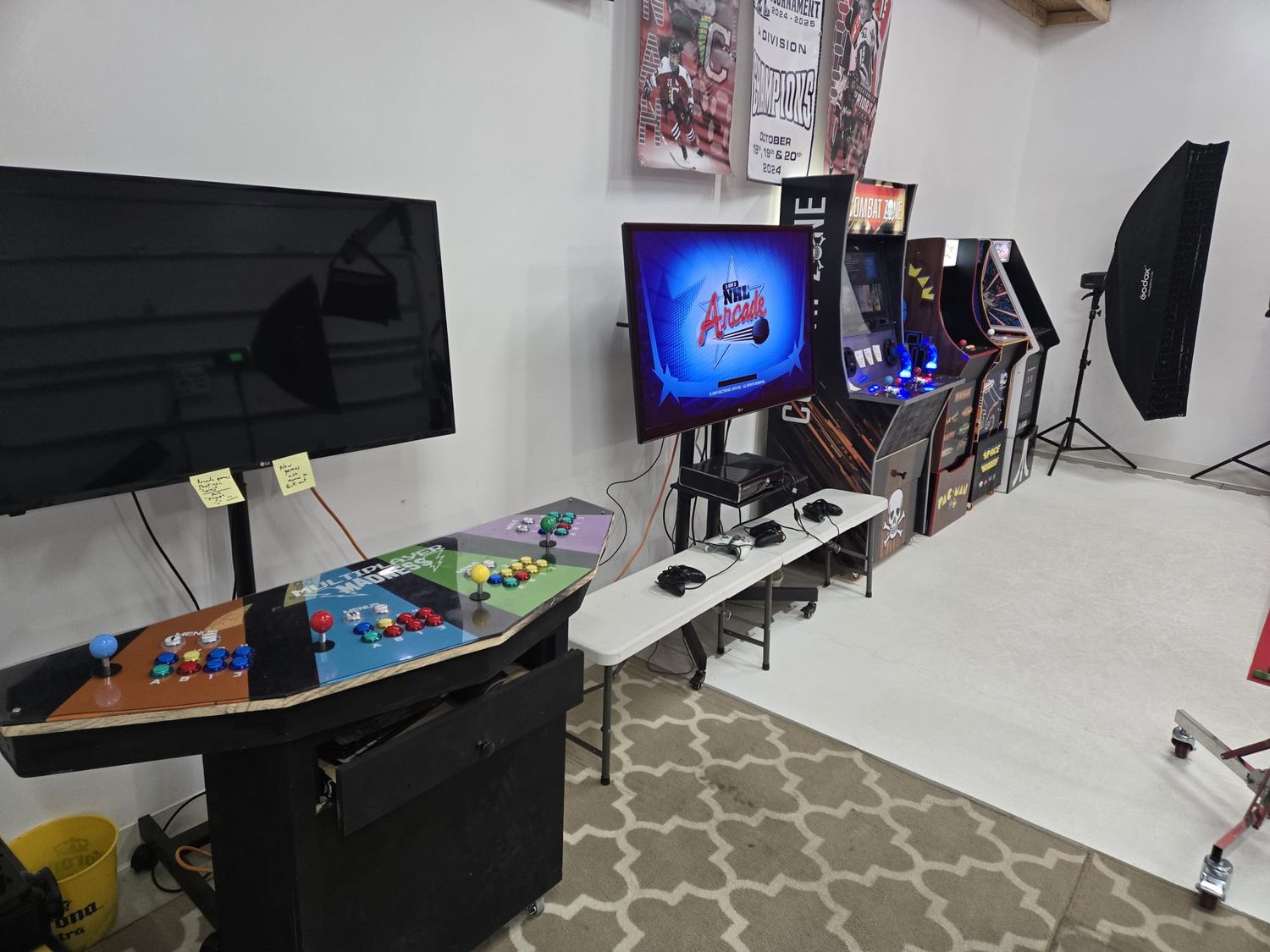 Multiple gaming and computer monitors displayed across a wall-mounted setup with black mounting brackets and decorative accents.