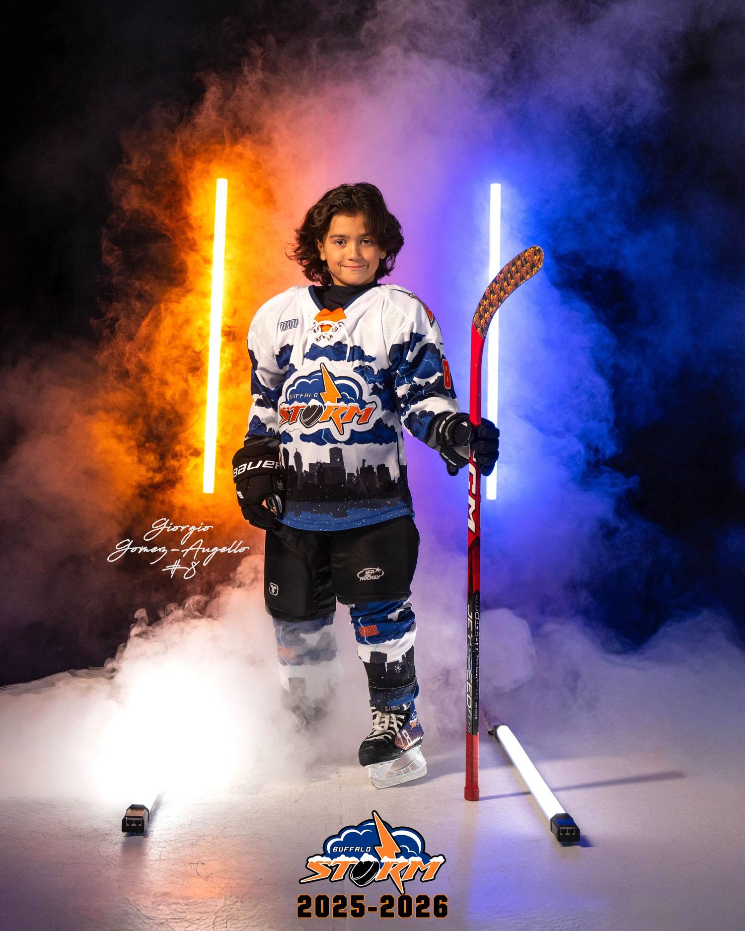 Hockey player poses with dramatic lighting effects and blue and orange smoke on ice rink during team photoshoot.
