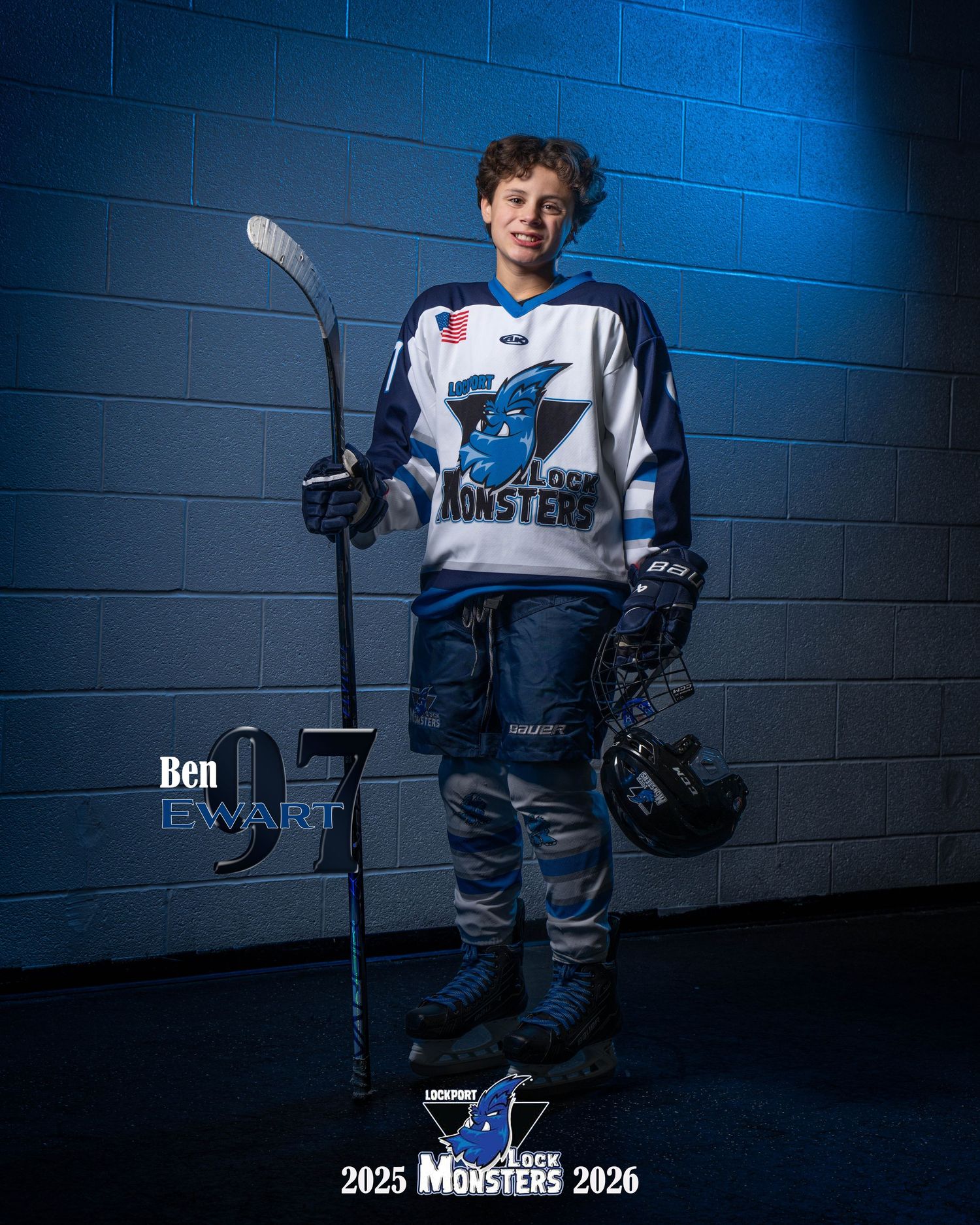Dramatic sports portrait of hockey player in blue and white uniform against dark blue backdrop with dramatic lighting.