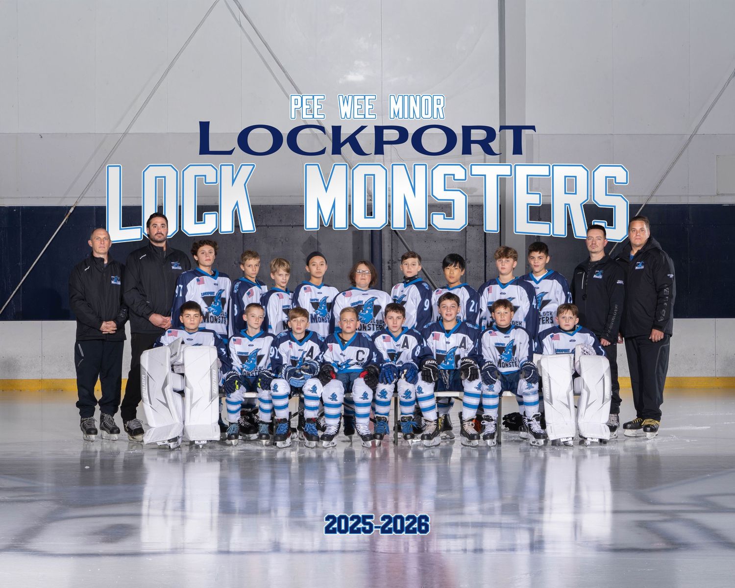 Hockey team members line up on the ice rink for a panoramic team photo in blue and white uniforms.