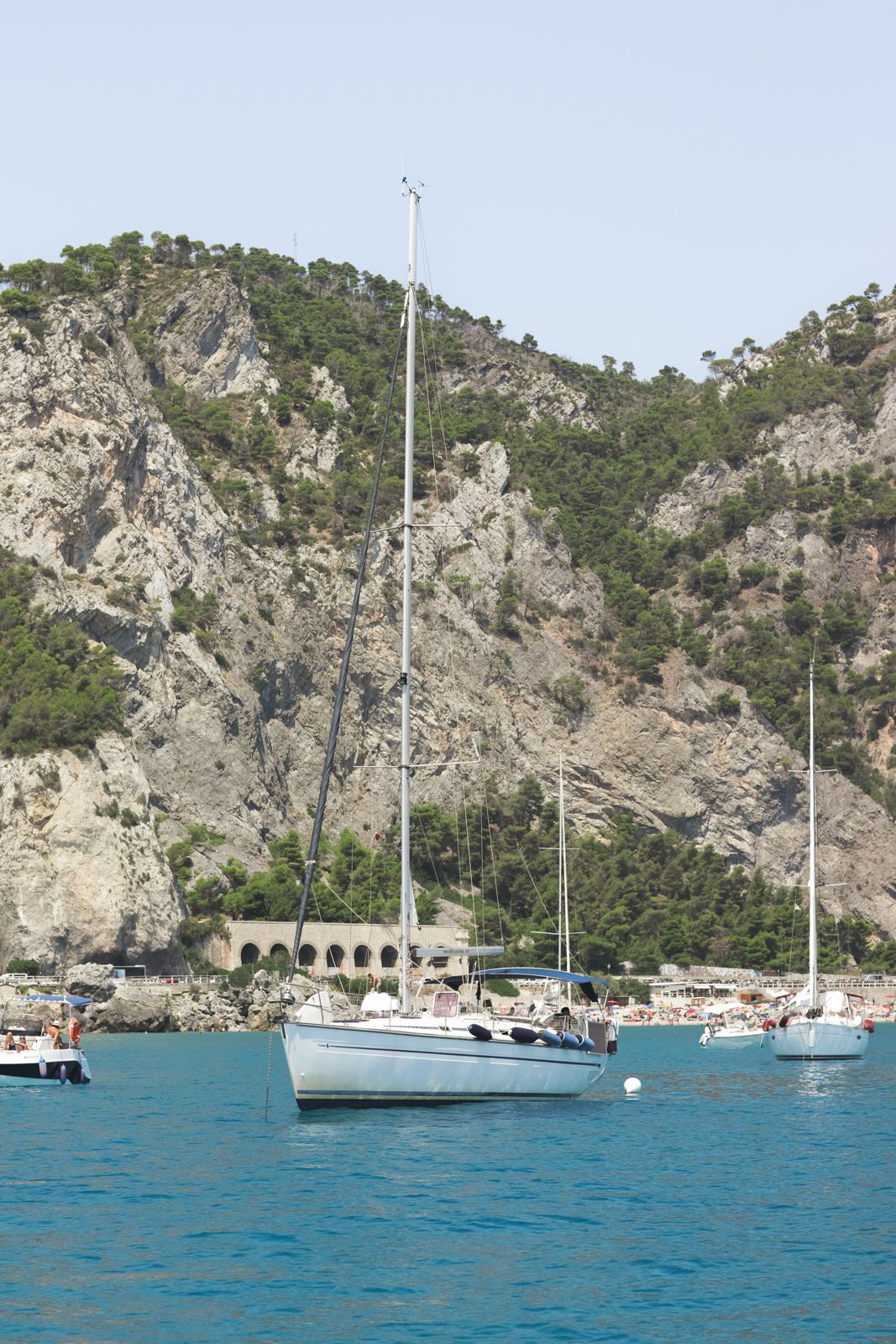 Sailboats anchored along the dramatic cliffs of Liguria, perfect backdrop for high-end wedding celebrations on the Italian Riviera.
