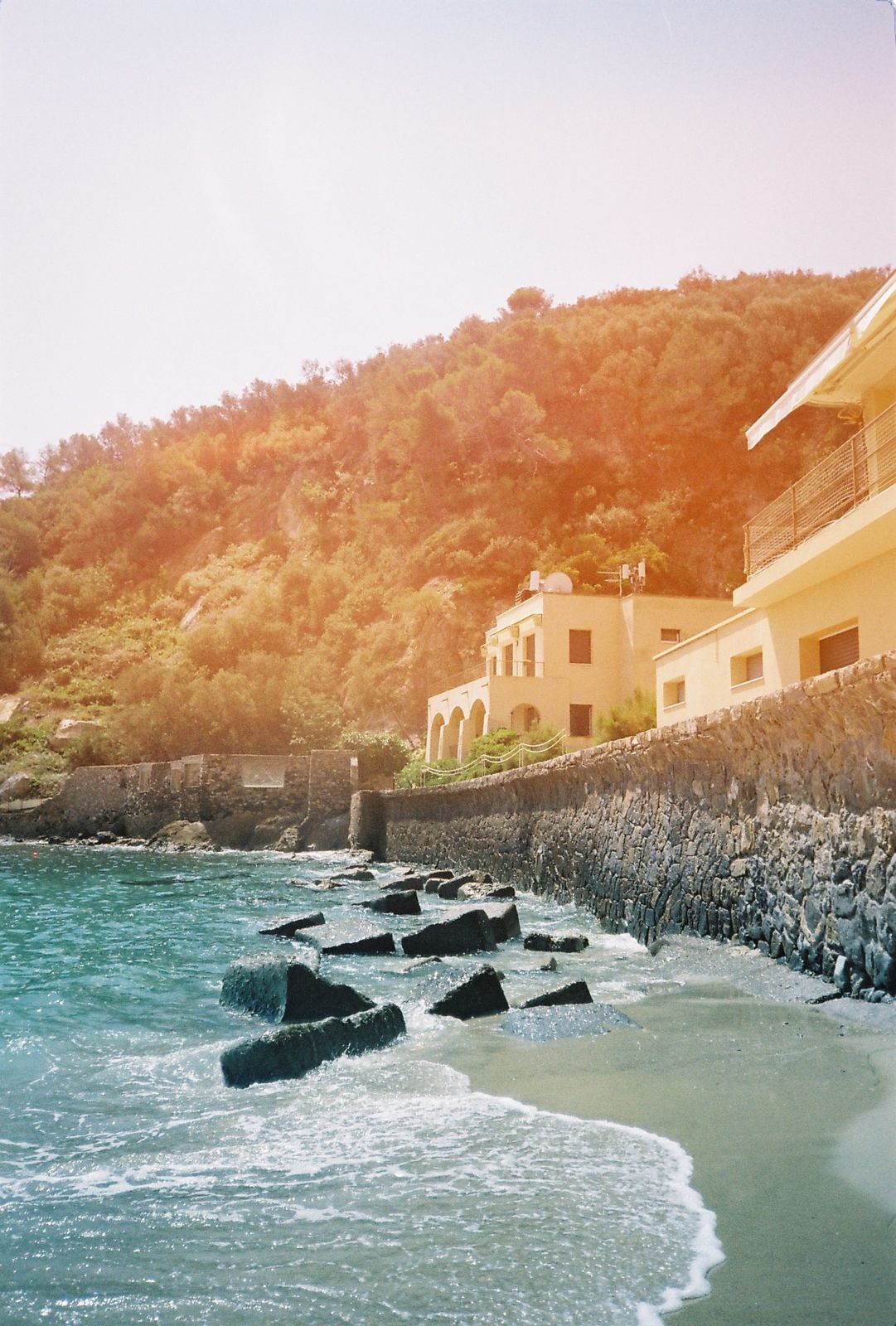 Coastal view of Liguria with turquoise sea and rocky shoreline, ideal for stylish destination weddings in Northern Italy.