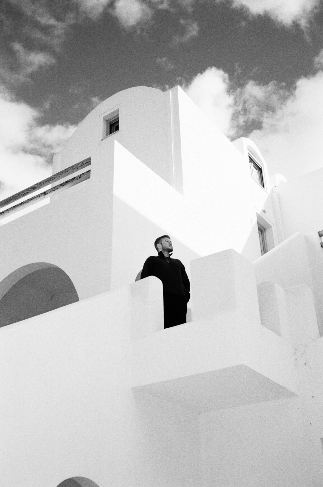Black and white portrait of Tobi, destination wedding videographer, looking into the camera with a calm and focused expression.
