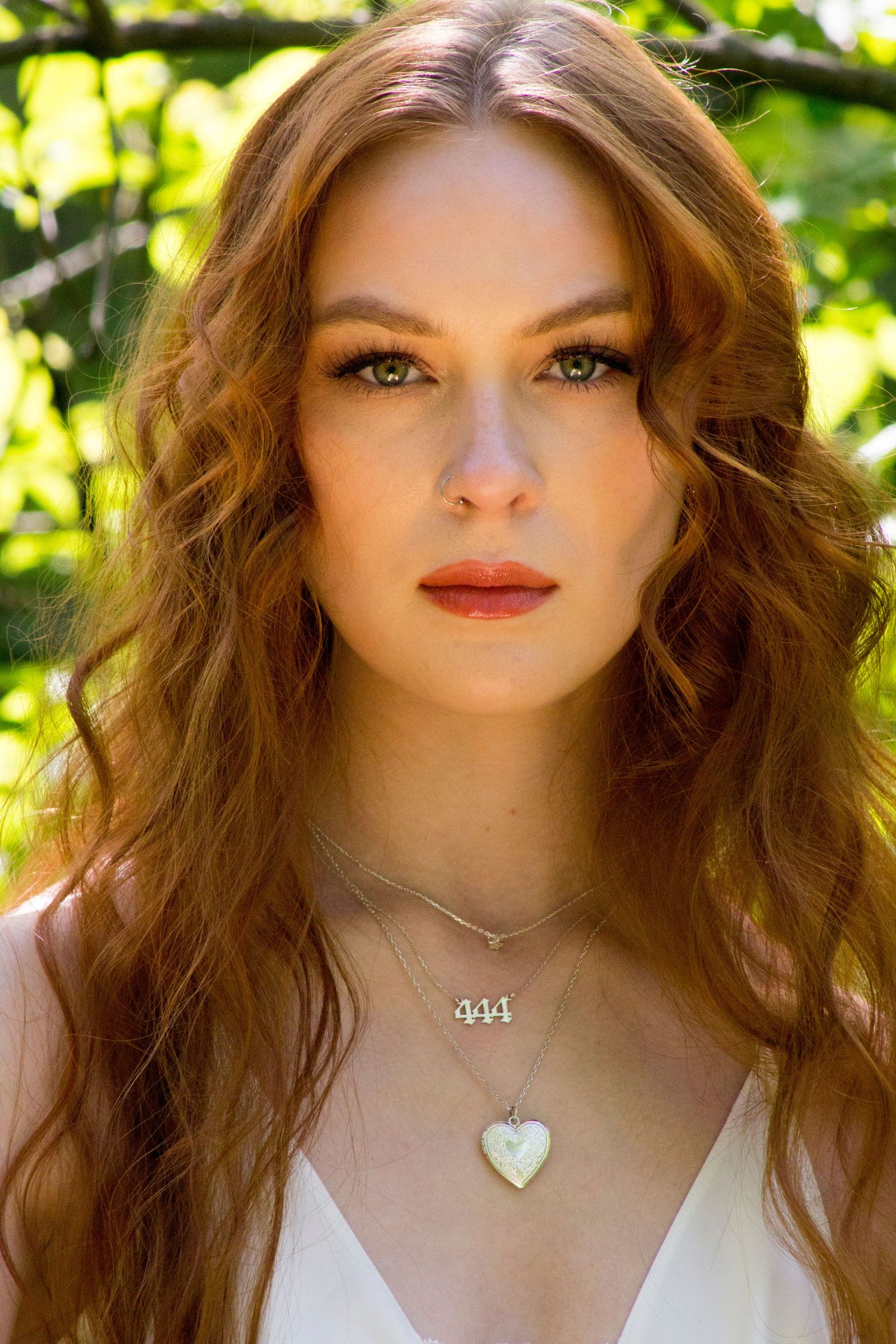 An artistic image of a woman staring at a camera basking in golden light.