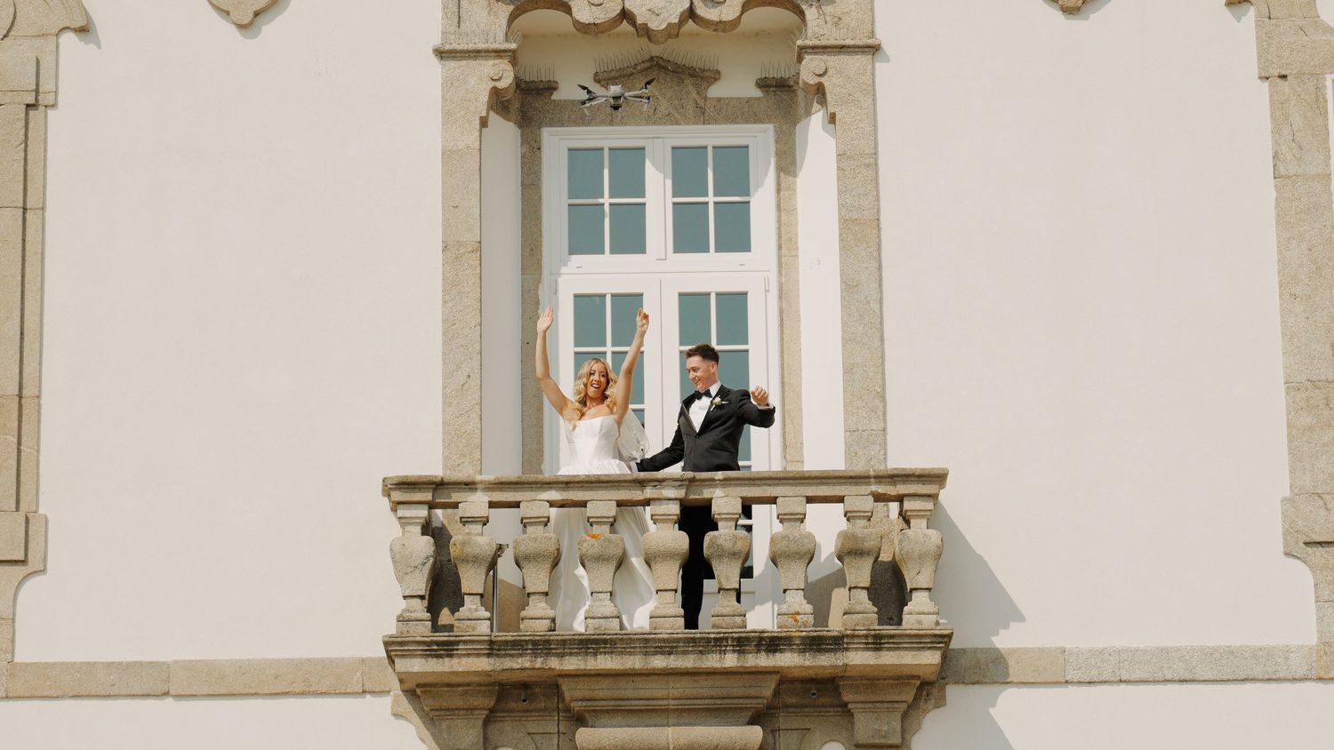 Architectural detail of a beige stone building with ornate window frames.