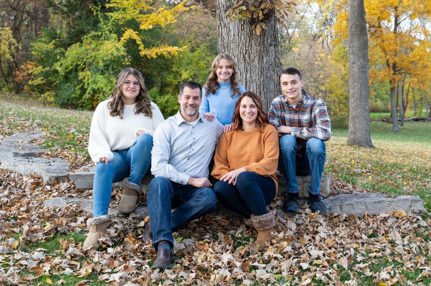 family sitting on rocks at park