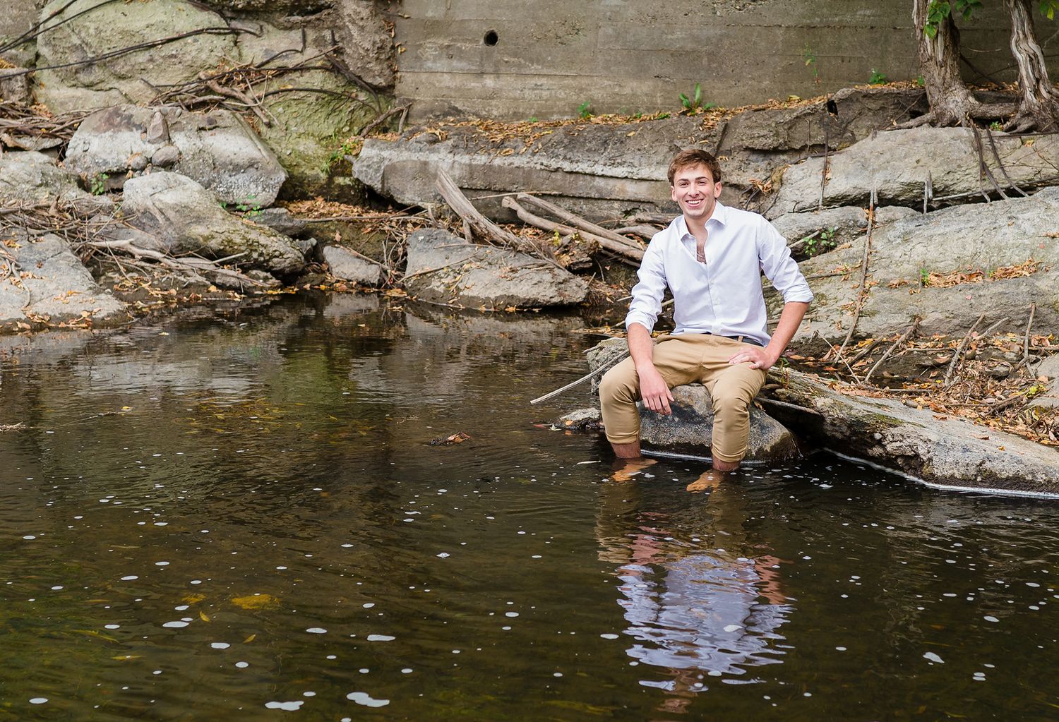 senior boy rocks on the creek