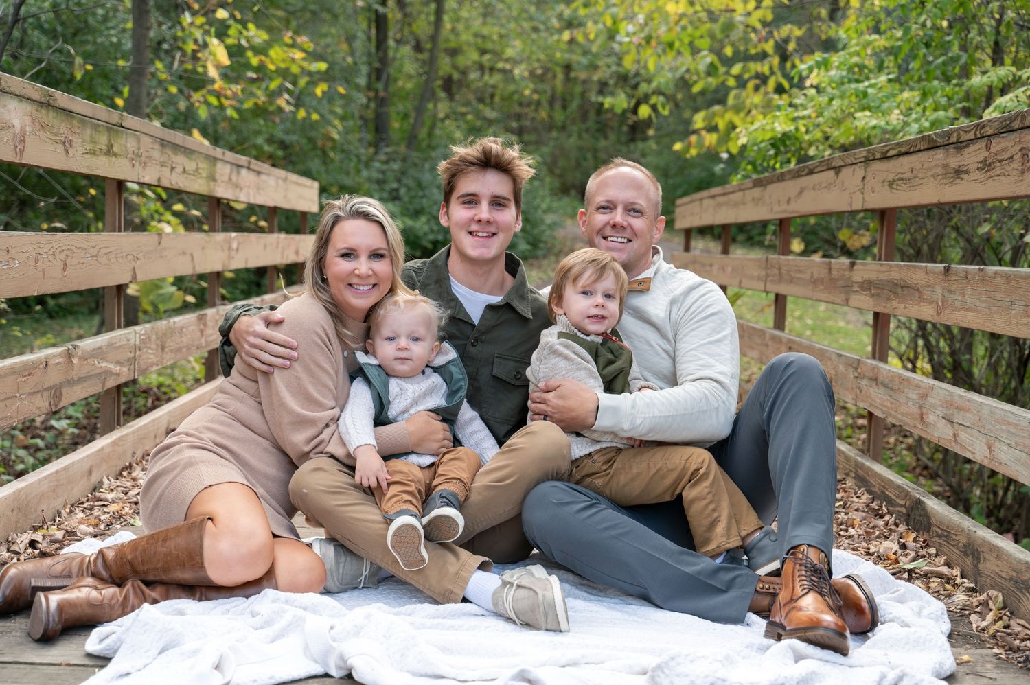family snuggling on bridge for a photo