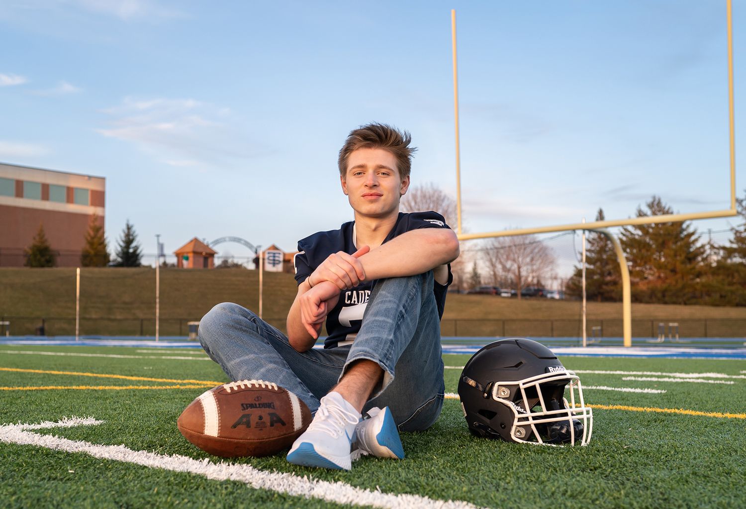 senior boy football field at sunset