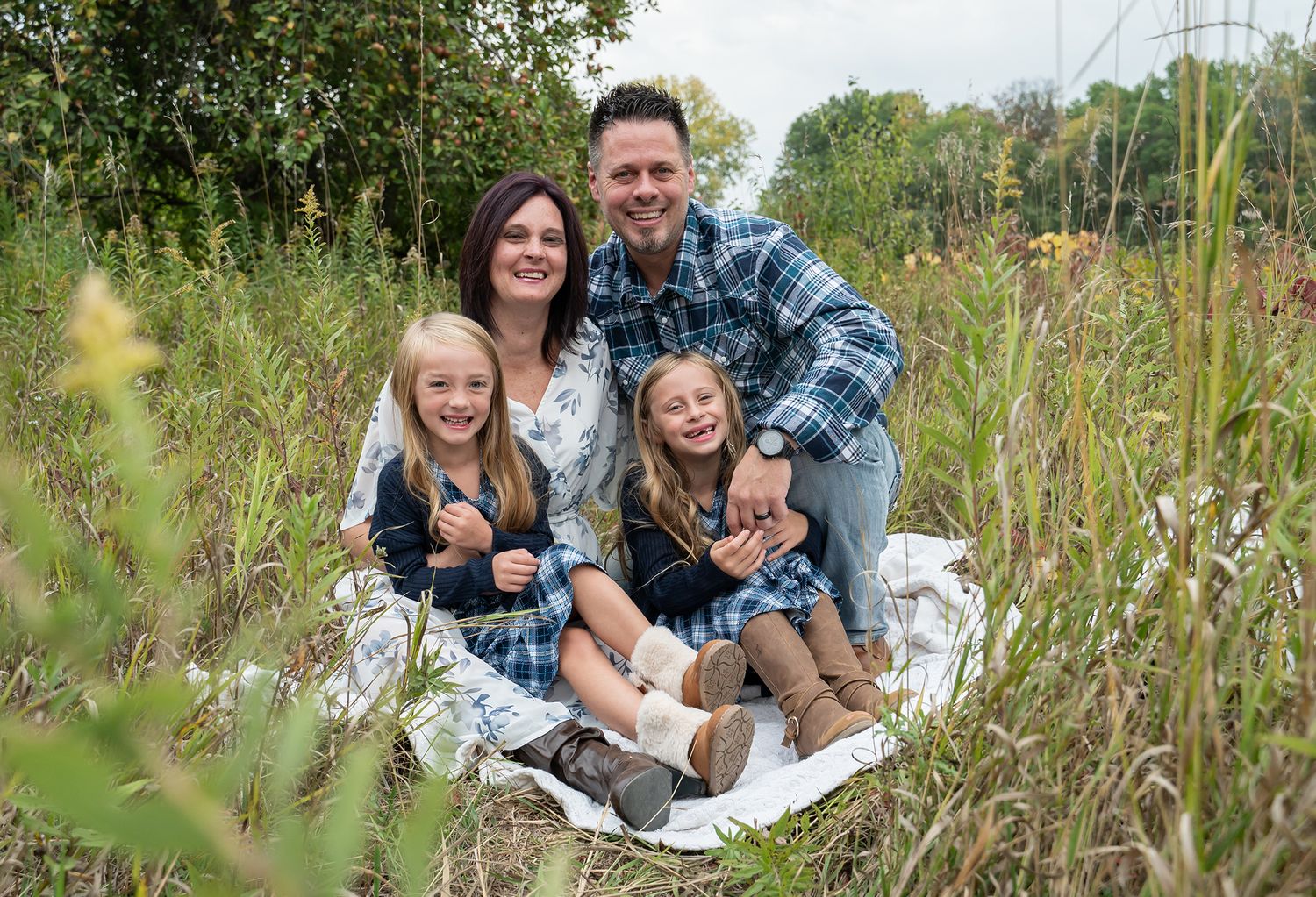 family cuddling in field