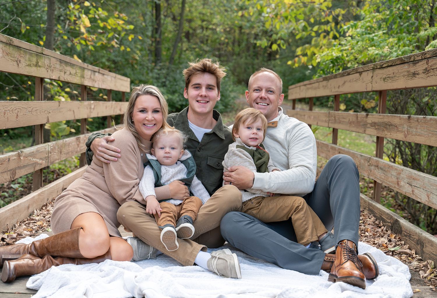 family snuggling on bridge