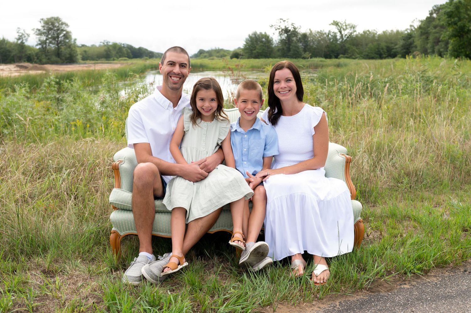 family in a field on couch