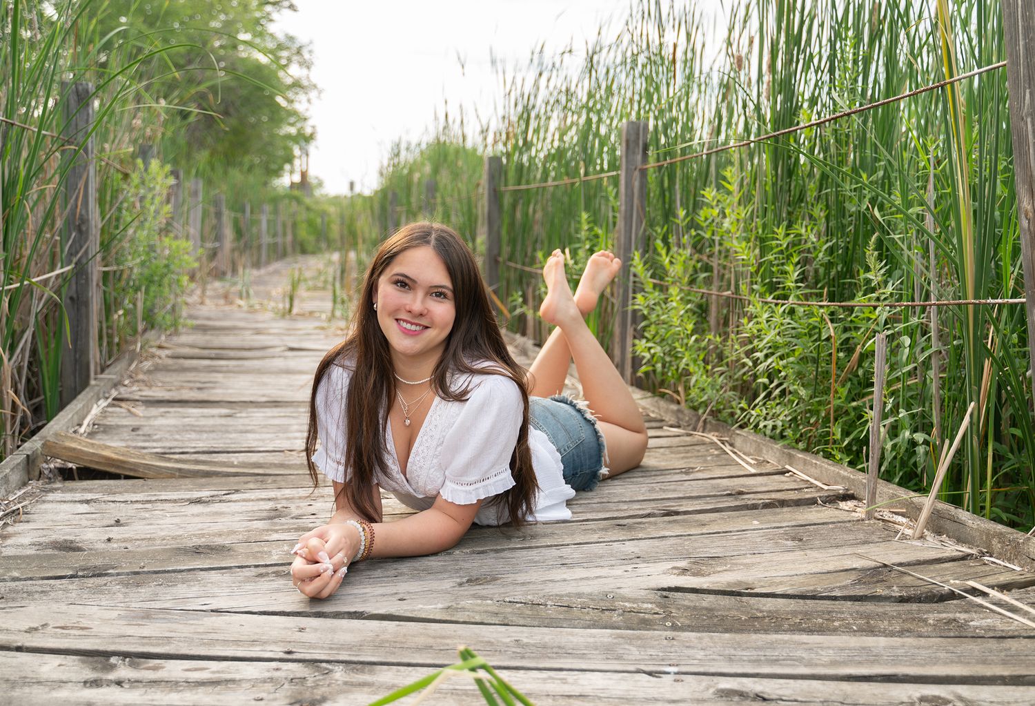 senior girl laying on boardwalk