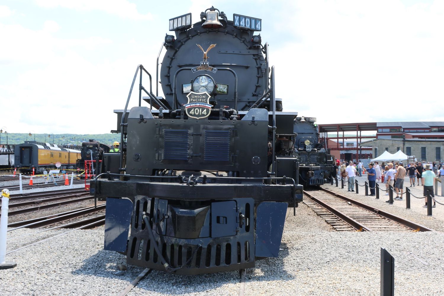Front view of a massive black steam locomotive number 4014 at a rail yard.