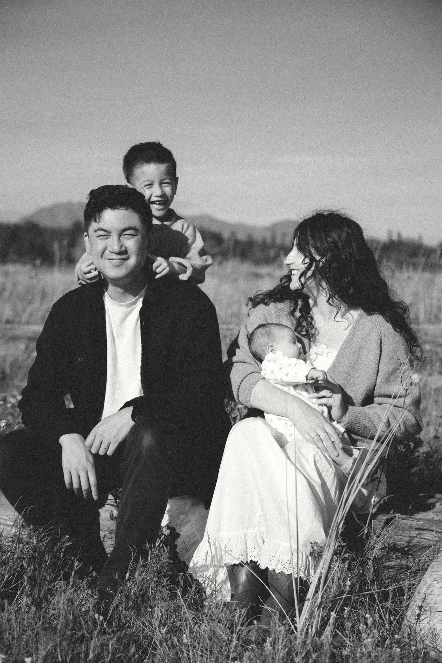 black and white family photo shoot with a couple, their toddler and their newborn outdoors in vancouver bc