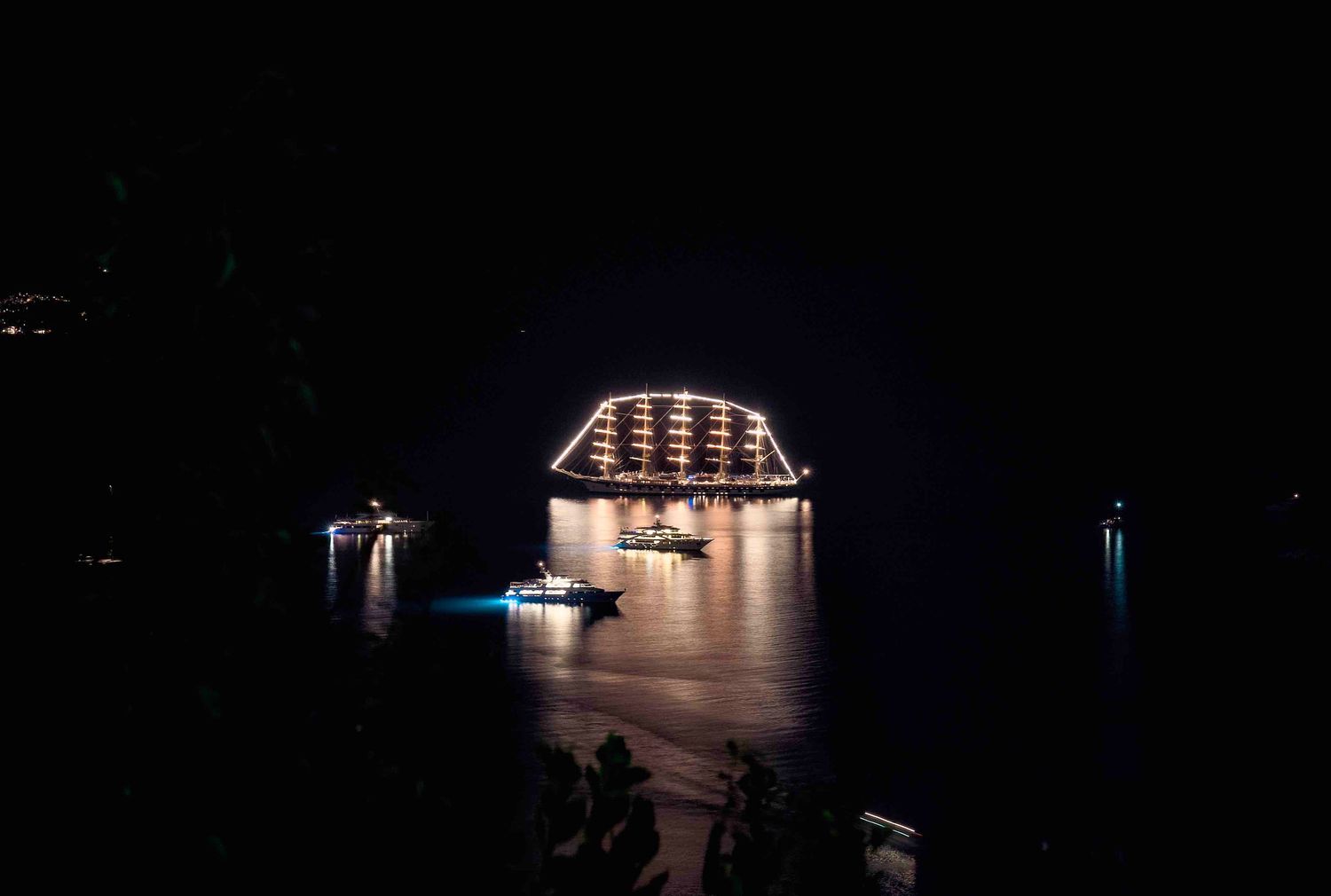 A dark concert stage illuminated by dramatic spotlights and glowing architectural elements creates a moody atmosphere.