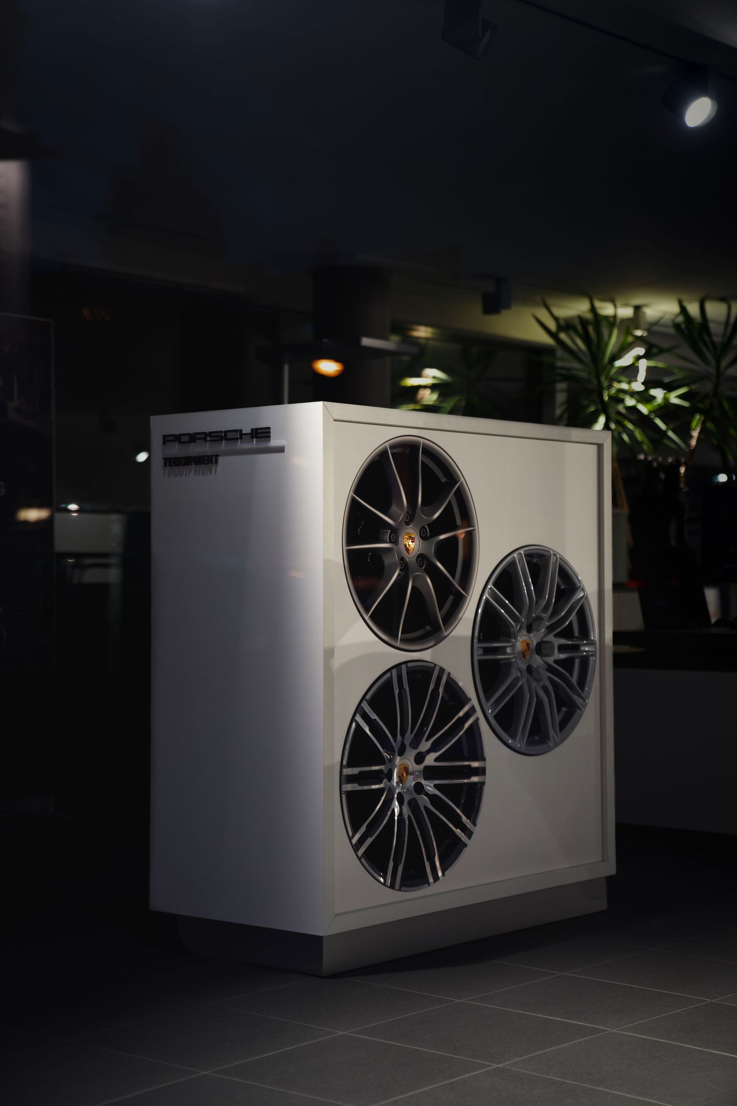 Large white industrial air conditioning units with multiple fans mounted in a dark setting.