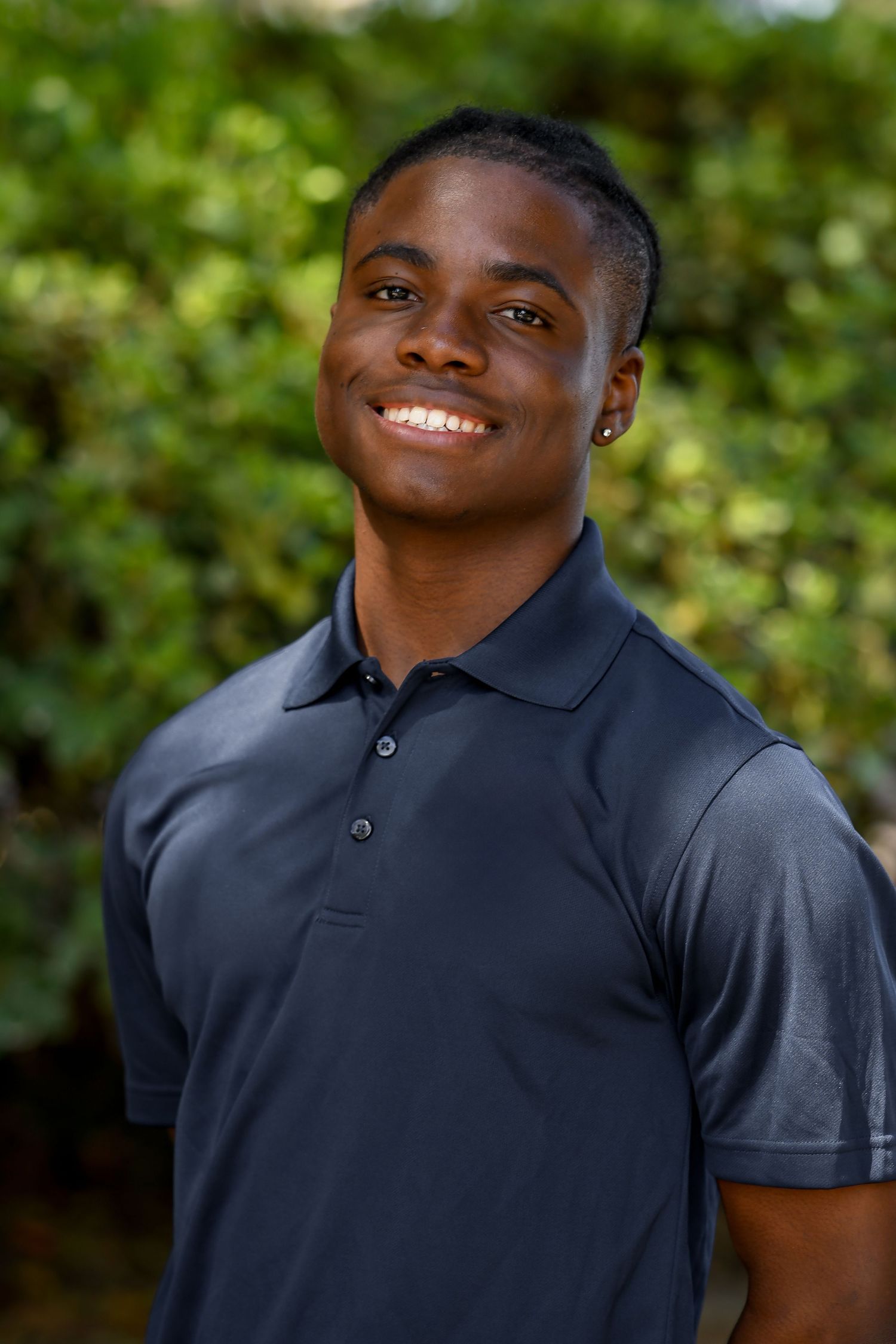Man smiling surrounding greenery