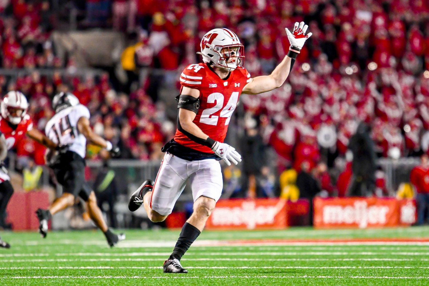 Football player holds his hand up for the ball