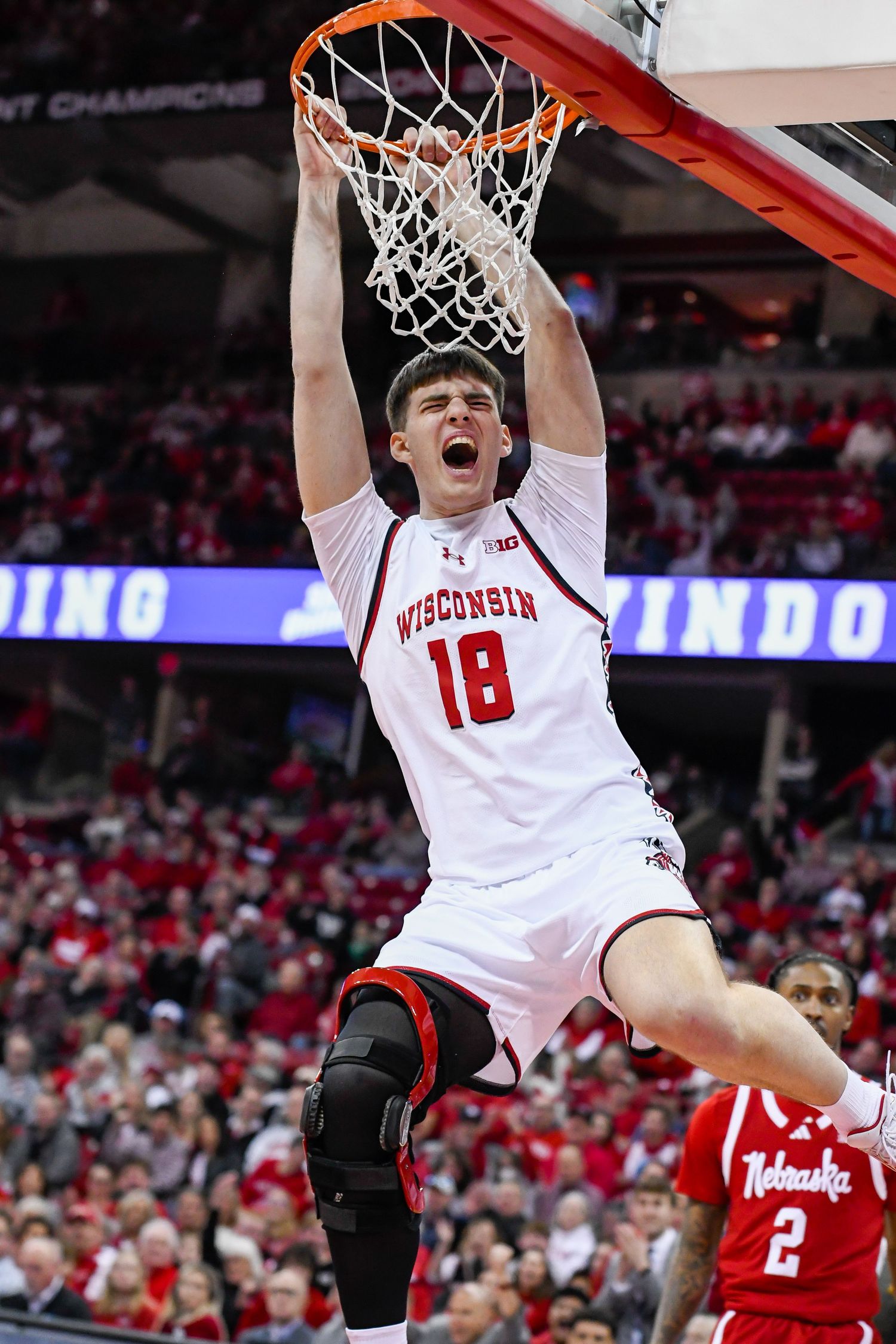 Male basketball player dunks the ball in the net