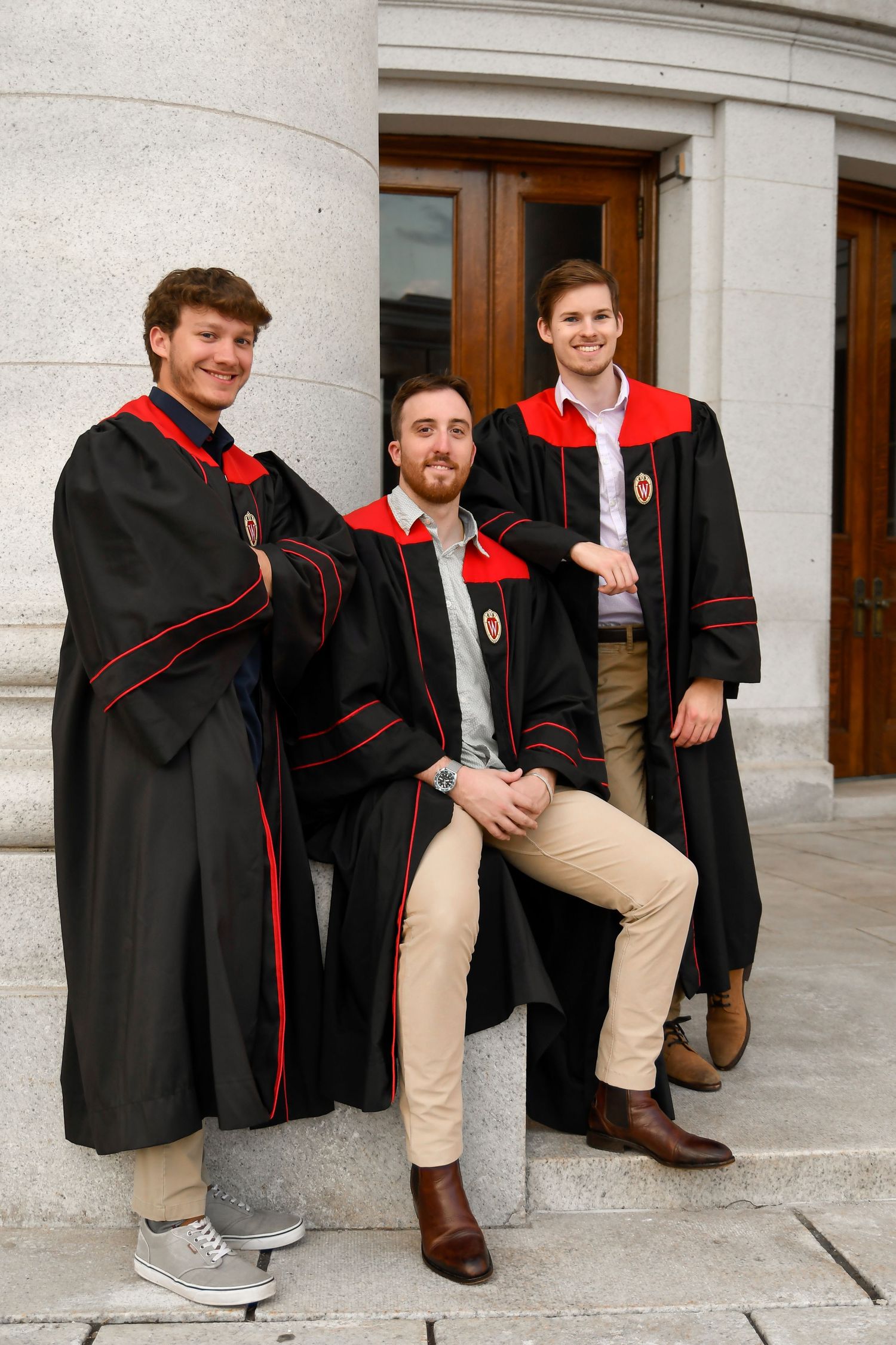 Group of three male graduates posing together.