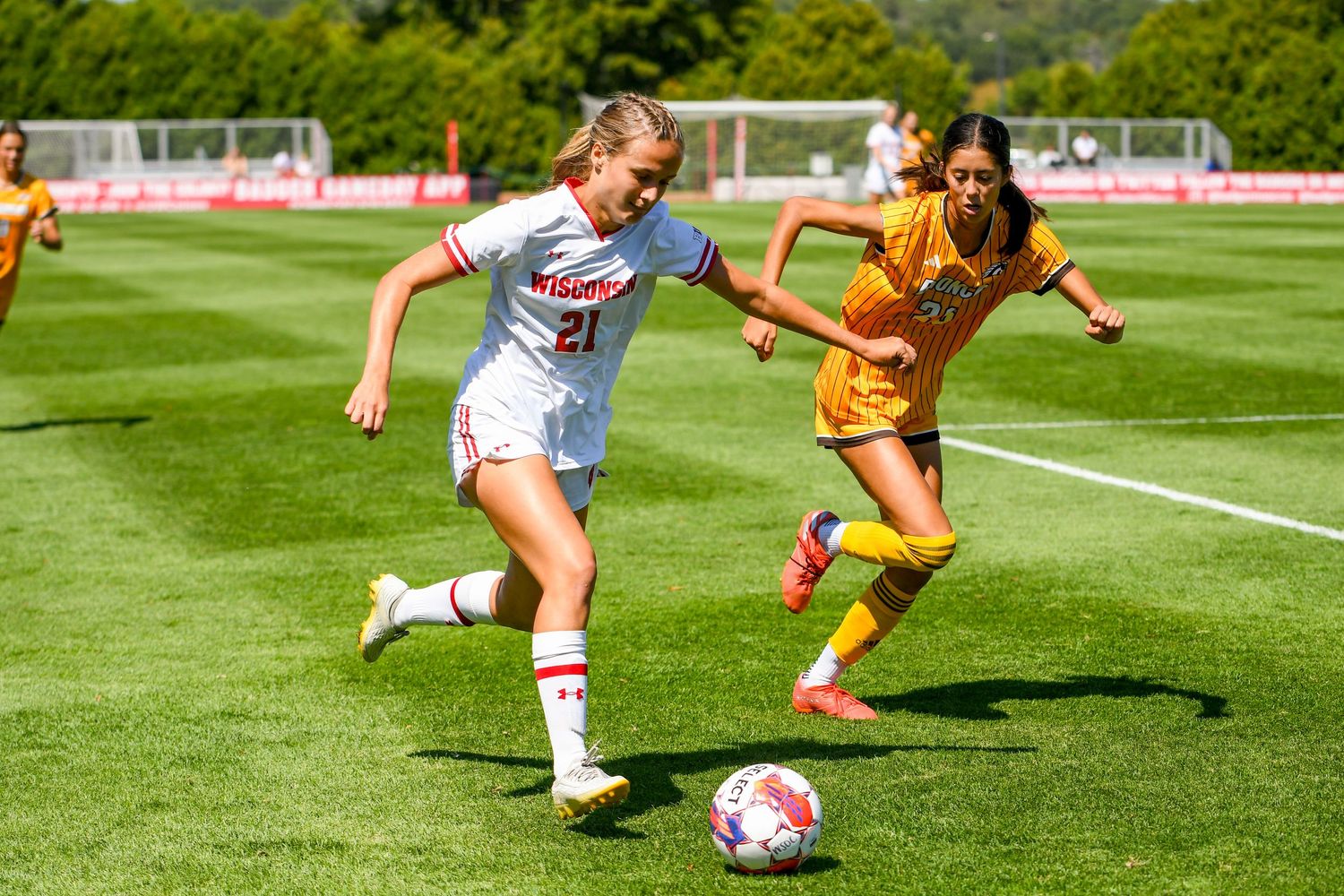 Two female soccer players running with the ball