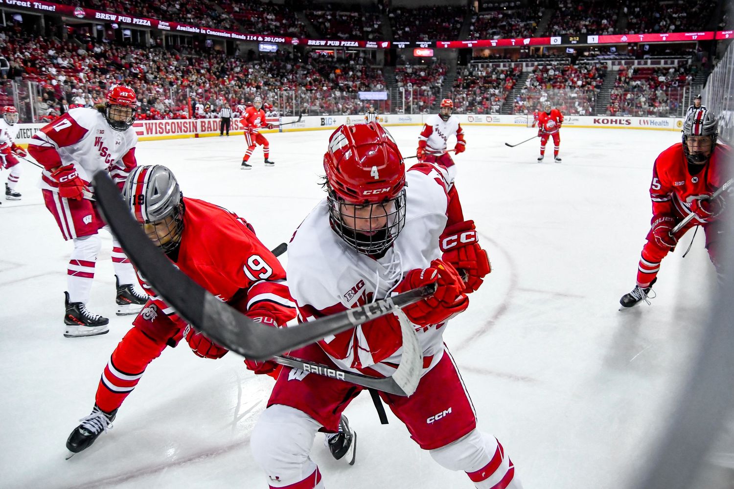 Hockey players on the ice with the stick close to the glass