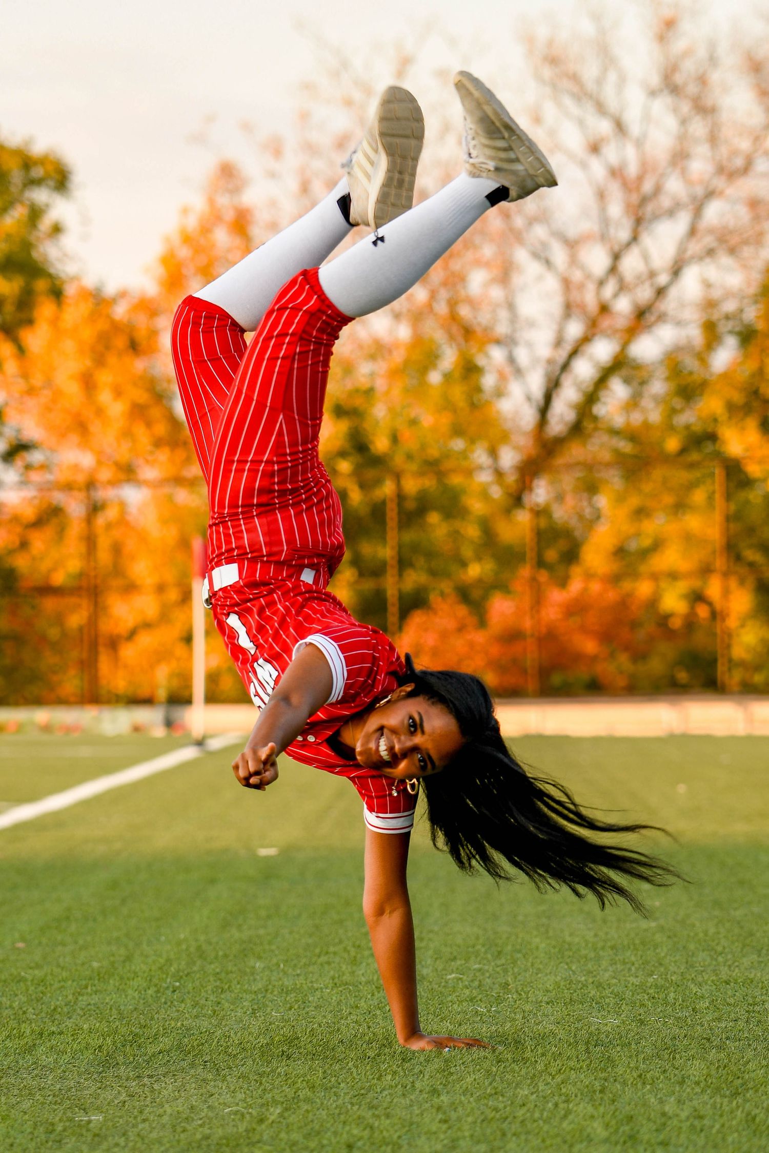 Girl smiling while doing a one handed handstand